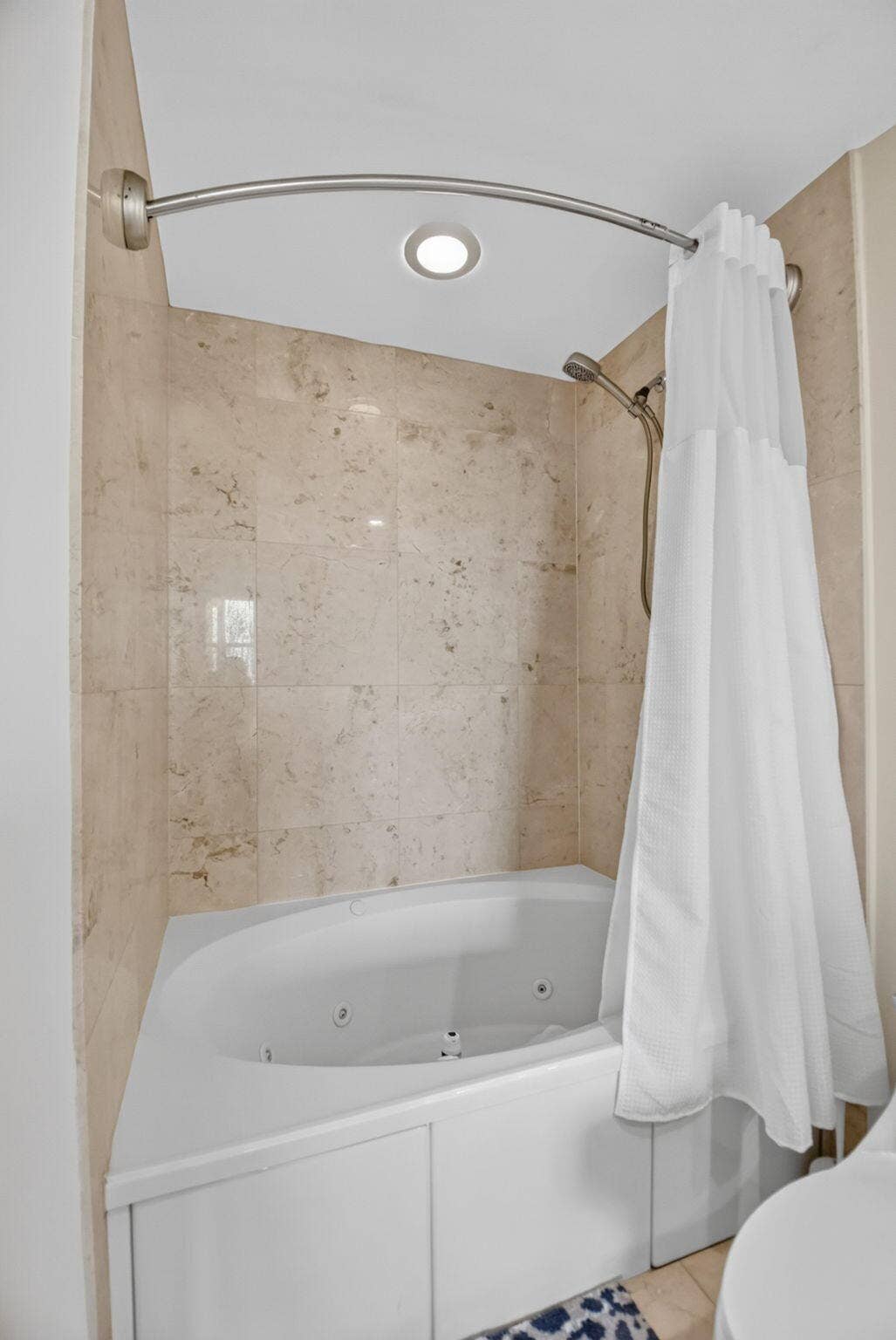 550 OKEECHOBEE Boulevard, #1618, West Palm Beach, West Palm Beach, FL 33401 Jetted corner bathtub with light-toned tiled surround, recessed ceiling lighting, and a brushed nickel shower rod