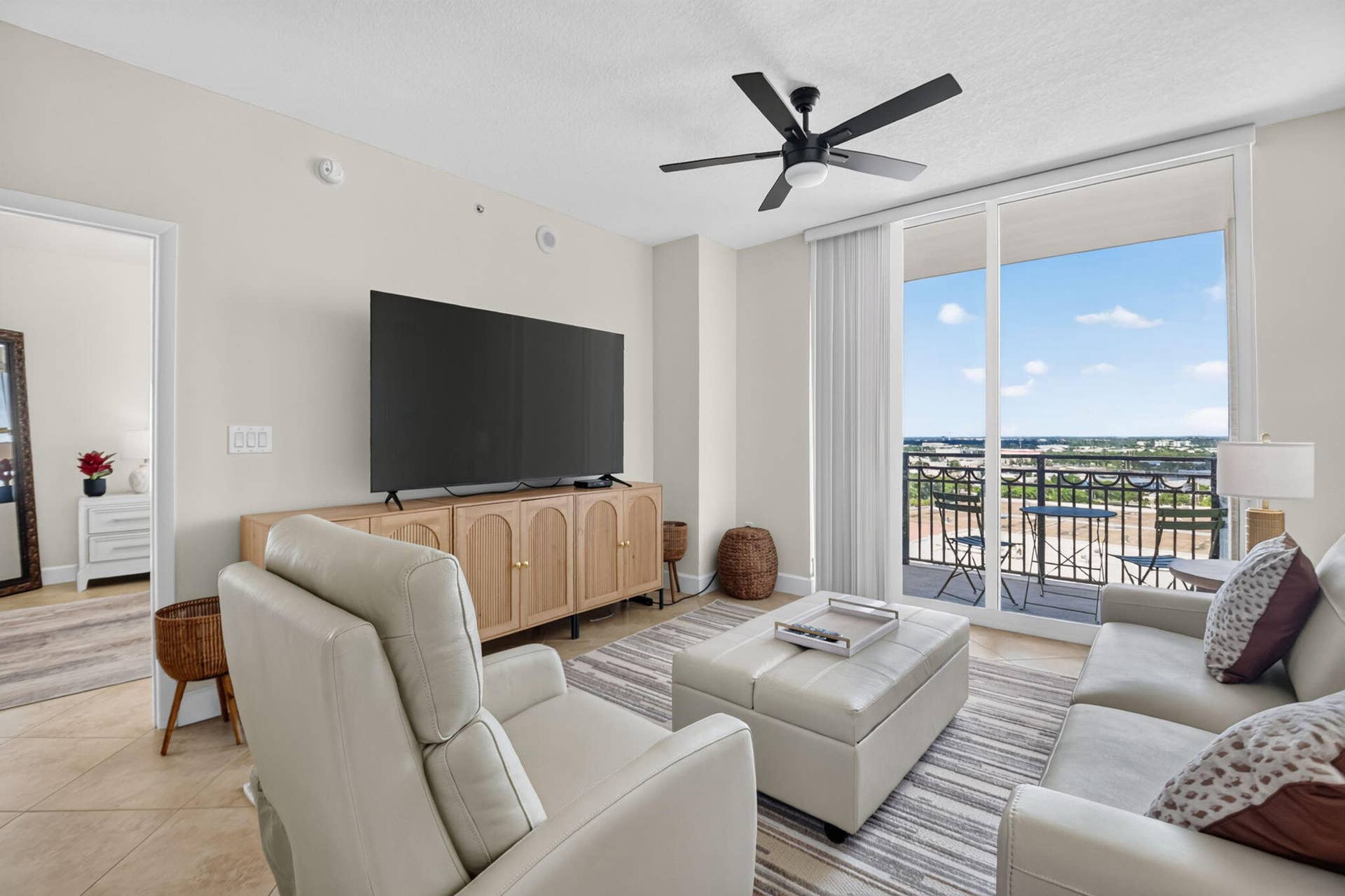 550 OKEECHOBEE Boulevard, #1618, West Palm Beach, West Palm Beach, FL 33401 Sliding glass doors leading to a private balcony, ceiling fan with integrated lighting, wood-finish console, recessed lighting, and tile flooring