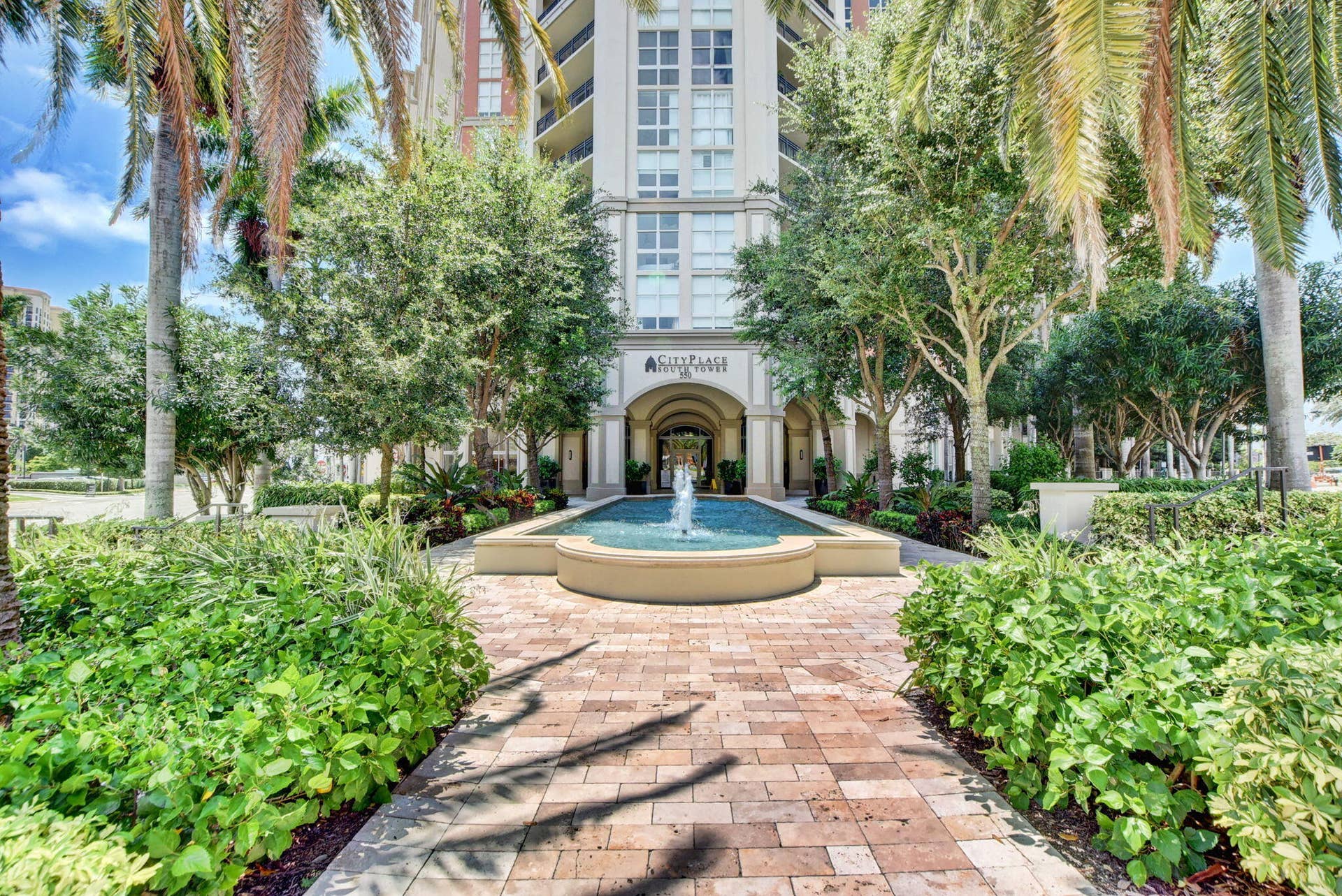 550 OKEECHOBEE Boulevard, #1618, West Palm Beach, West Palm Beach, FL 33401 Multi-story residential building with arched entryway, a central water feature, and a paver pathway
