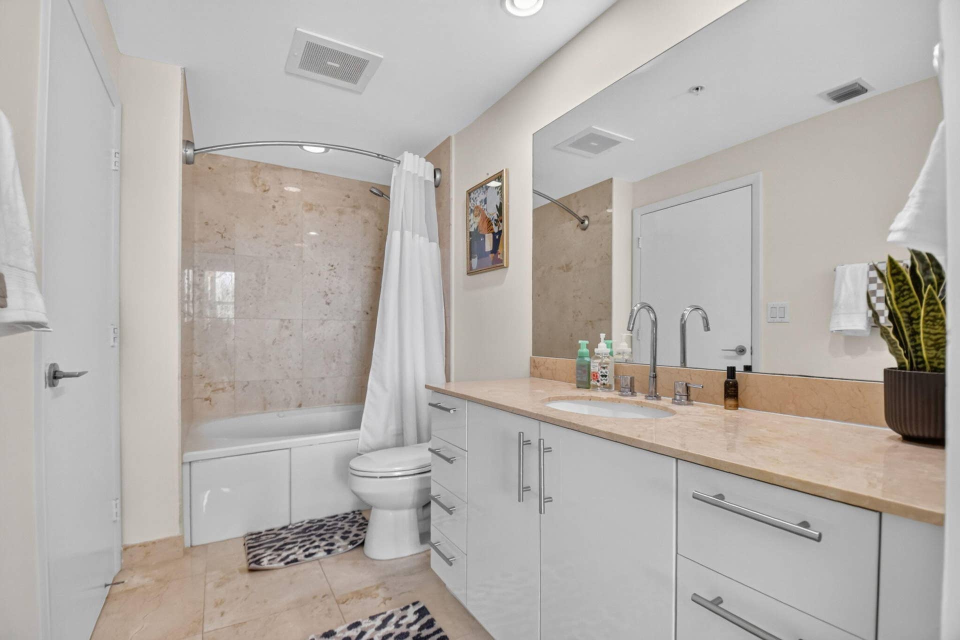 550 OKEECHOBEE Boulevard, #1618, West Palm Beach, West Palm Beach, FL 33401 Bathtub and shower combination with tiled surround, single vanity with integrated sink, stone countertop, and large wall-mounted mirror
