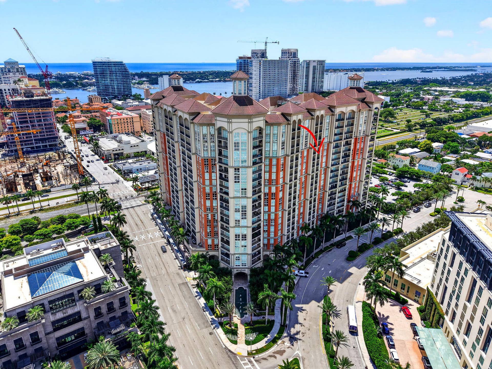 550 OKEECHOBEE Boulevard, #1618, West Palm Beach, West Palm Beach, FL 33401 Multi-story building featuring balconies, a tile roof, and a palm-lined street