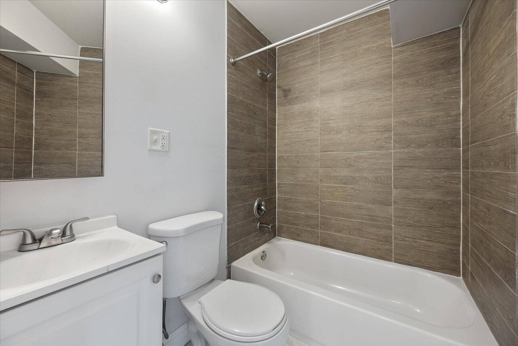714 W Lakewood Road, #B, West Palm Beach, West Palm Beach, FL 33405 Contemporary bathroom featuring a white vanity with integrated sink, chrome faucet, and full-height tiled shower surround