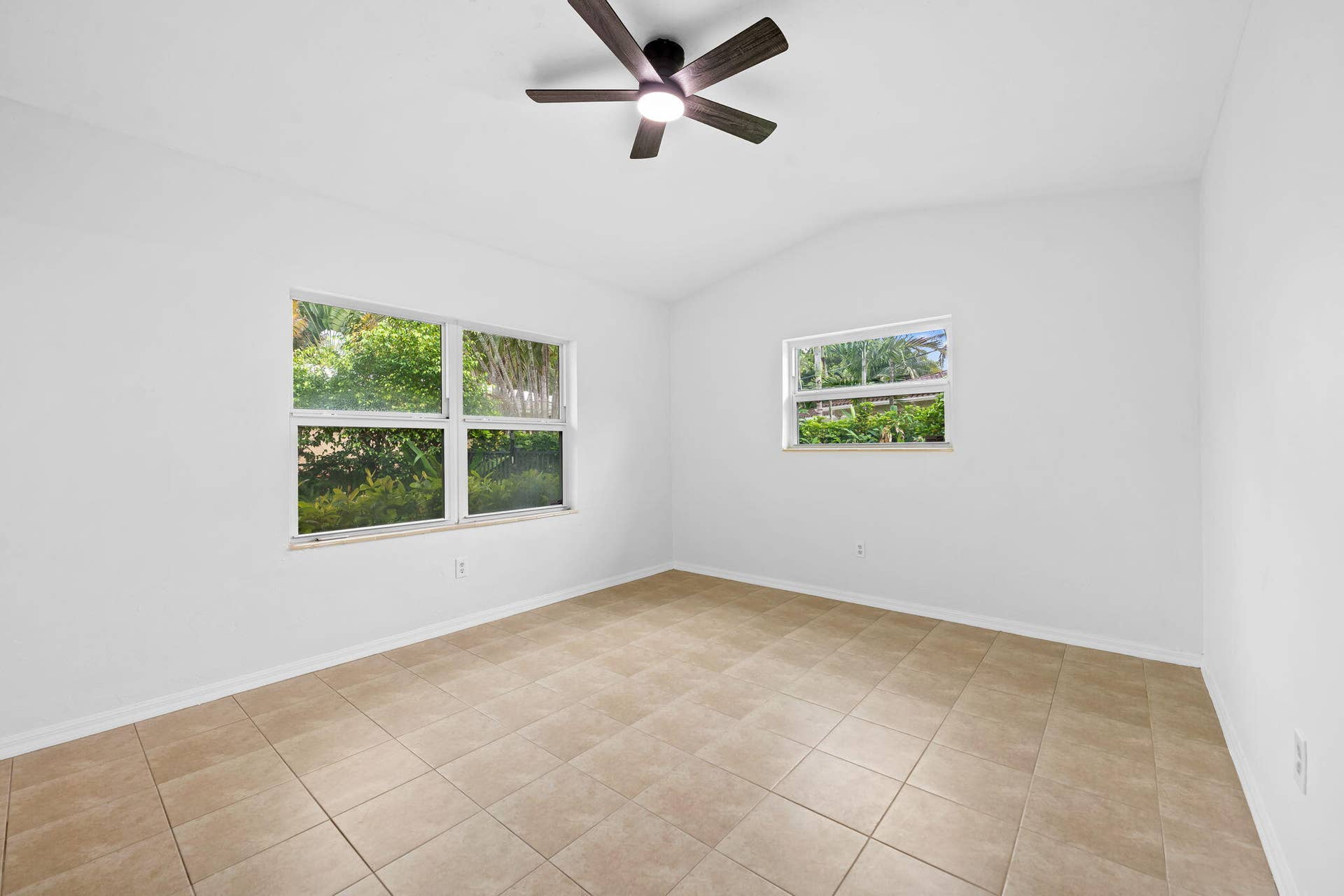 1705 NE 26TH Avenue, Fort Lauderdale, FL 33305 Vaulted ceiling, tiled flooring, ceiling fan with light fixture, and multiple windows