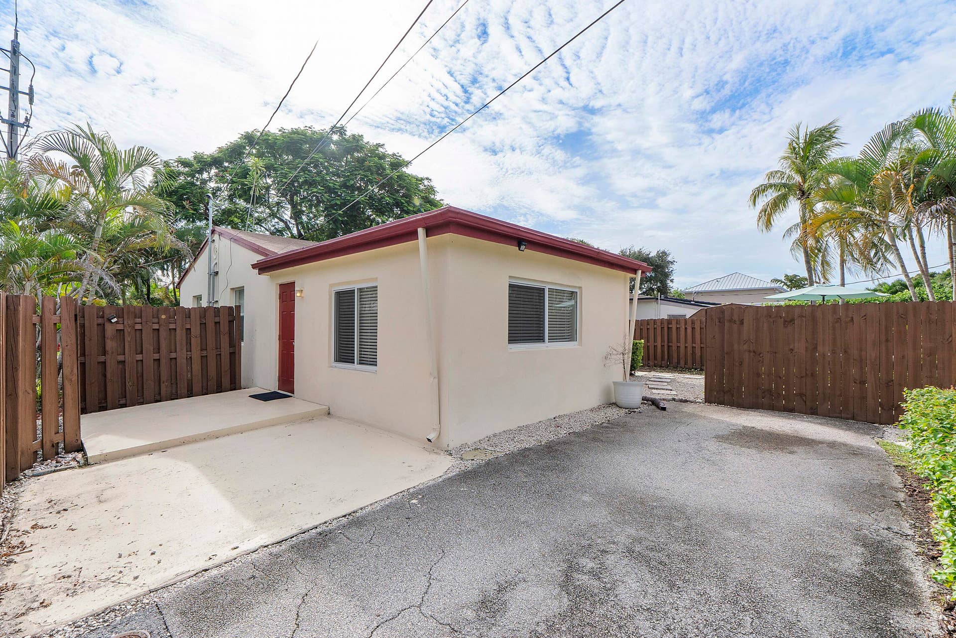 another side and back view with driveway enough for multiple cars. More parking beyond fence