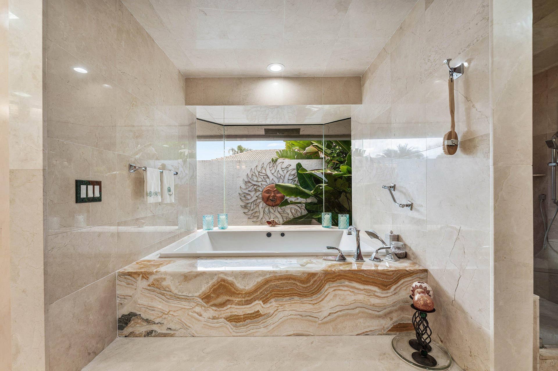 56 NORTHWOODS Lane, Boynton Beach, FL 33436 Built-in soaking tub with deck-mounted fixtures, surrounded by an onyx accent panel and light-toned tile walls