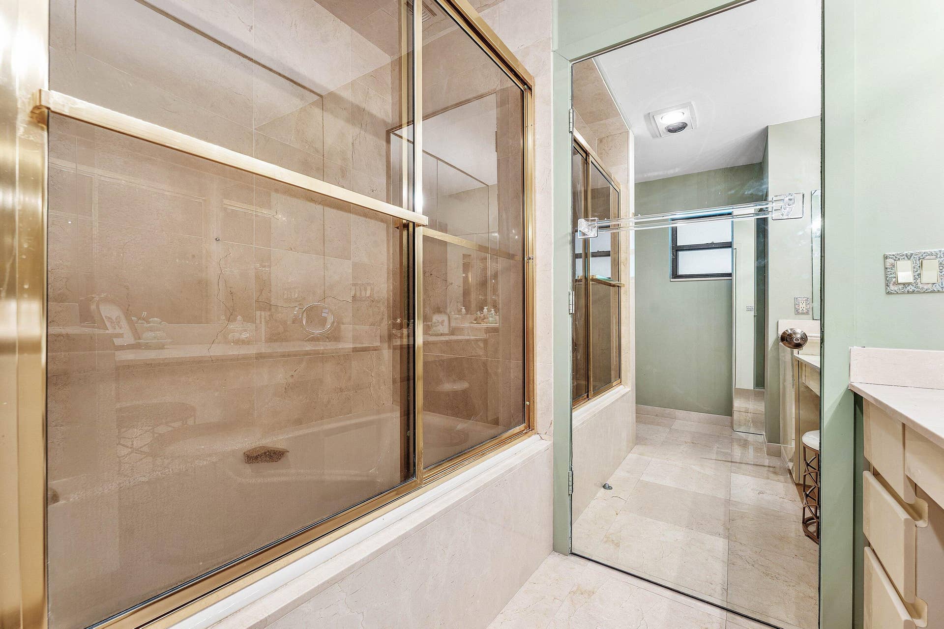 56 NORTHWOODS Lane, Boynton Beach, FL 33436 Full bathroom featuring a glass-enclosed shower with brass-toned framing, light-toned wall tile, and a built-in tub