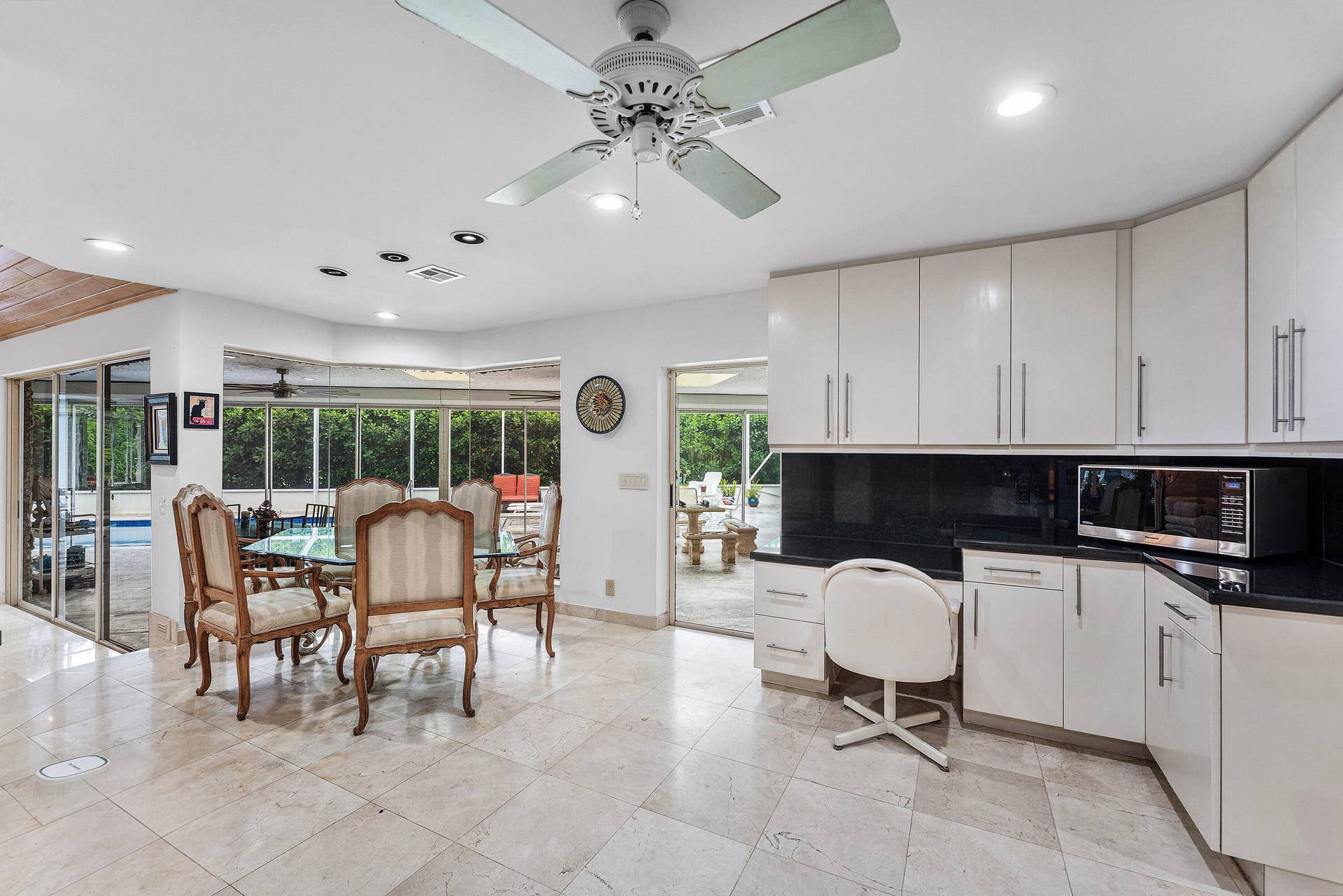 56 NORTHWOODS Lane, Boynton Beach, FL 33436 Polished tile flooring throughout, white cabinetry with dark countertops, recessed lighting, and expansive glass sliding doors