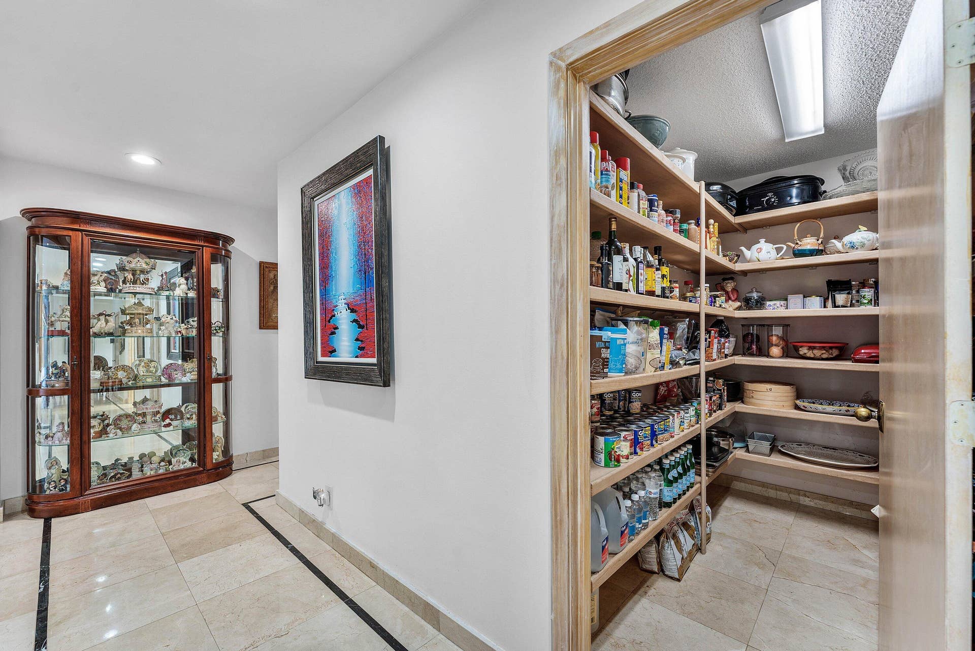 56 NORTHWOODS Lane, Boynton Beach, FL 33436 Spacious pantry featuring extensive wood shelving, integrated lighting, and tile flooring