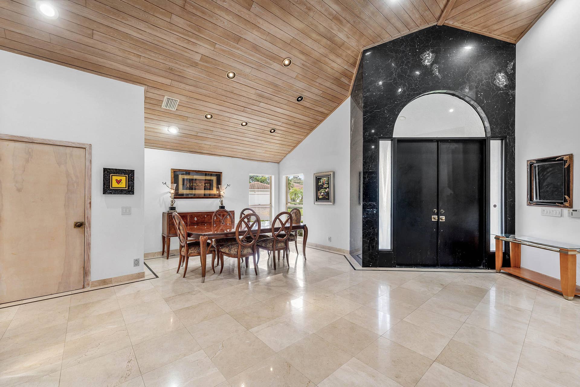 56 NORTHWOODS Lane, Boynton Beach, FL 33436 Vaulted wood-finish ceilings with recessed lighting, black double entry doors, a black stone accent wall, and polished tile flooring