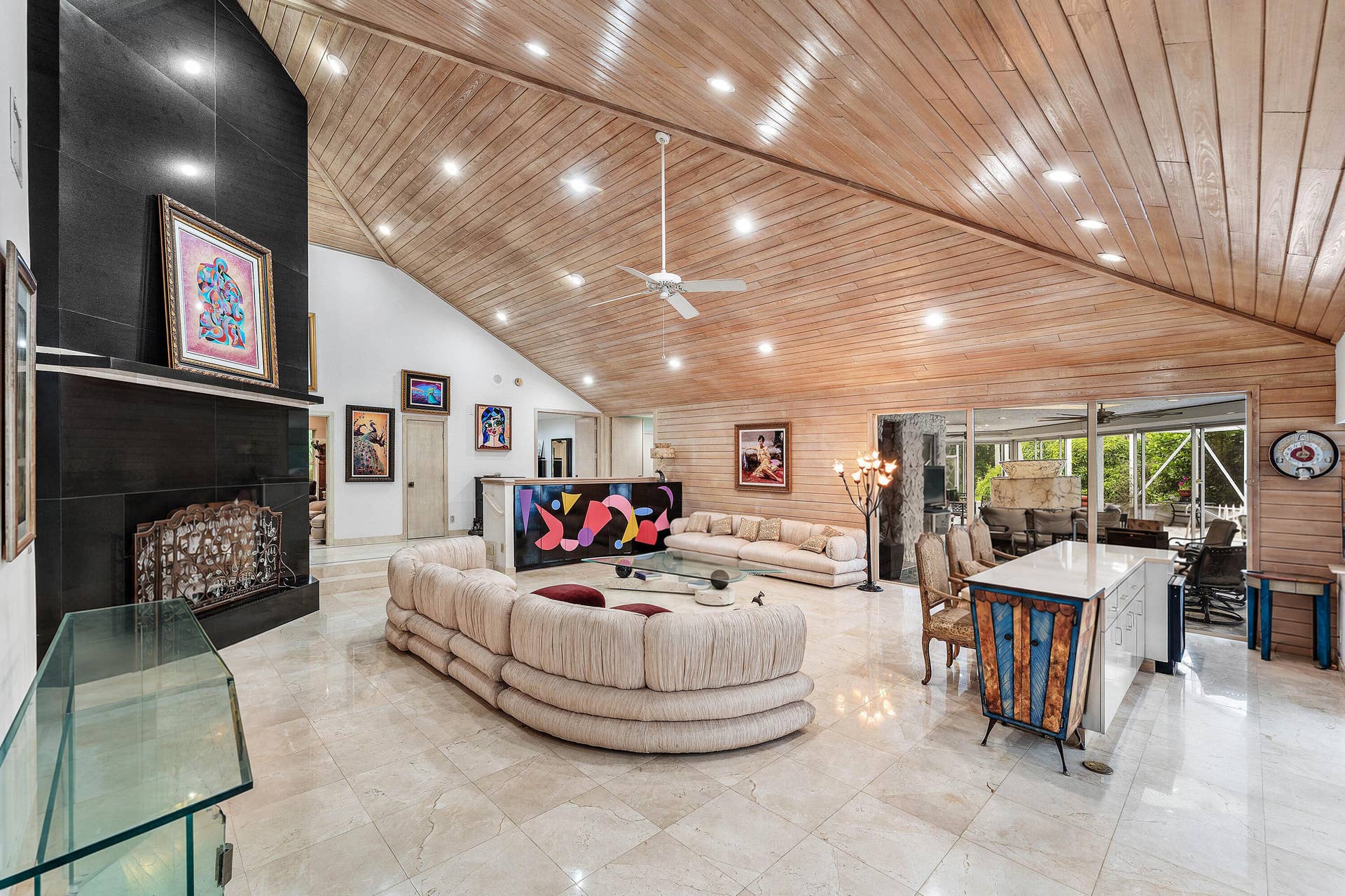 56 NORTHWOODS Lane, Boynton Beach, FL 33436 Vaulted wood-paneled ceiling with recessed lighting, large format tile flooring, black tile fireplace with mantel, and built-in white kitchen island with counter seating