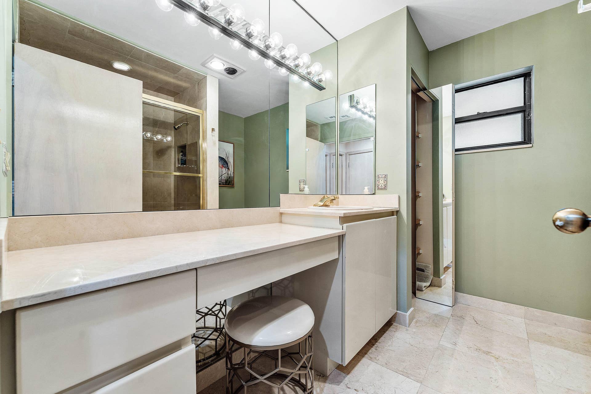 56 NORTHWOODS Lane, Boynton Beach, FL 33436 Built-in vanity with light-toned countertop, integrated cabinetry, and full-width mirror