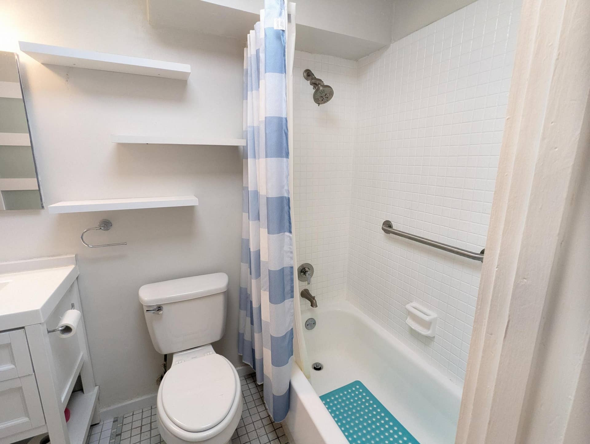 1800 N ANDREWS Avenue, #5B, Fort Lauderdale, Fort Lauderdale, FL 33311 Floating wall shelves, a built-in bathtub, and white subway tile surround
