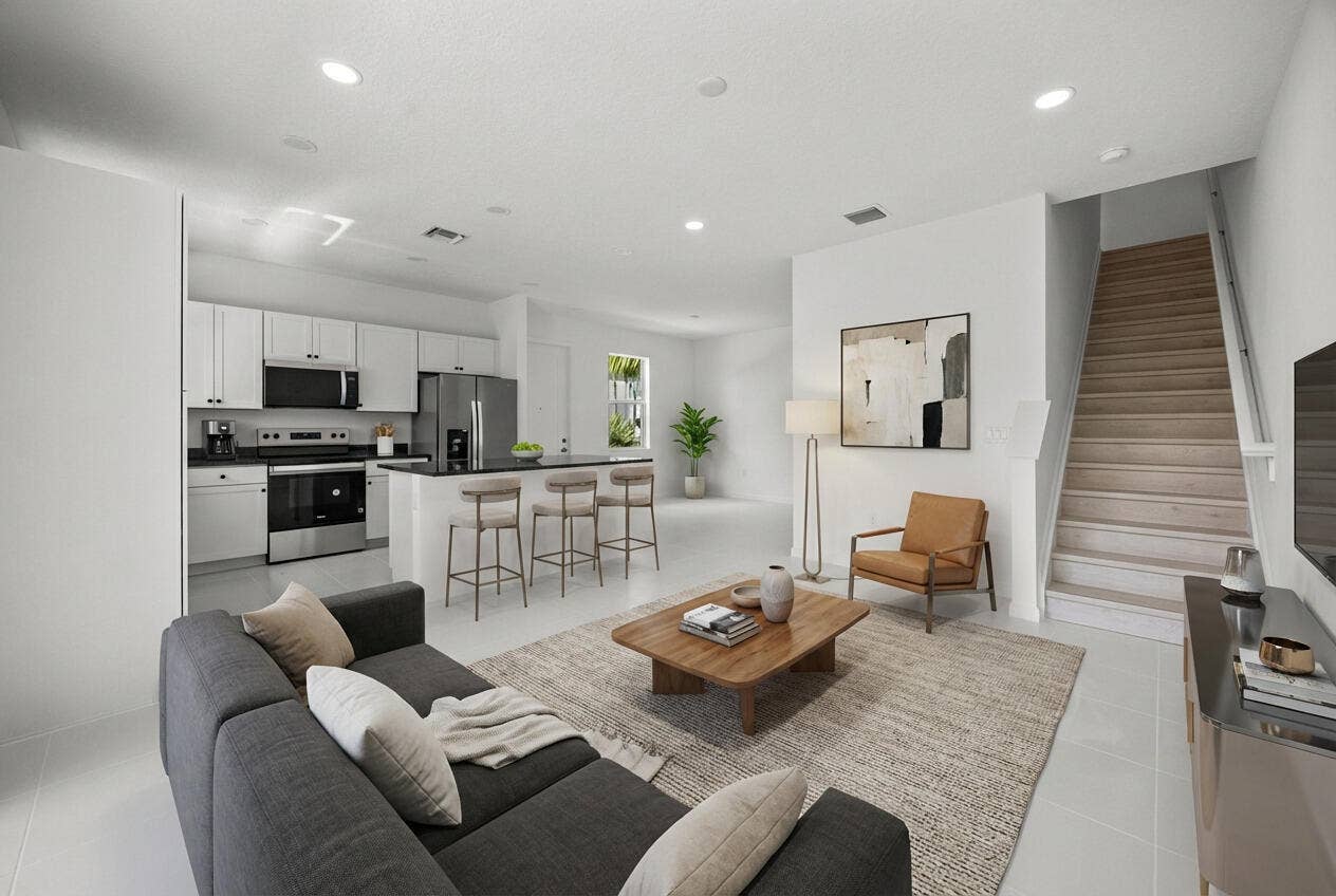 Open-concept living area with white walls, recessed lighting, and light-toned flooring