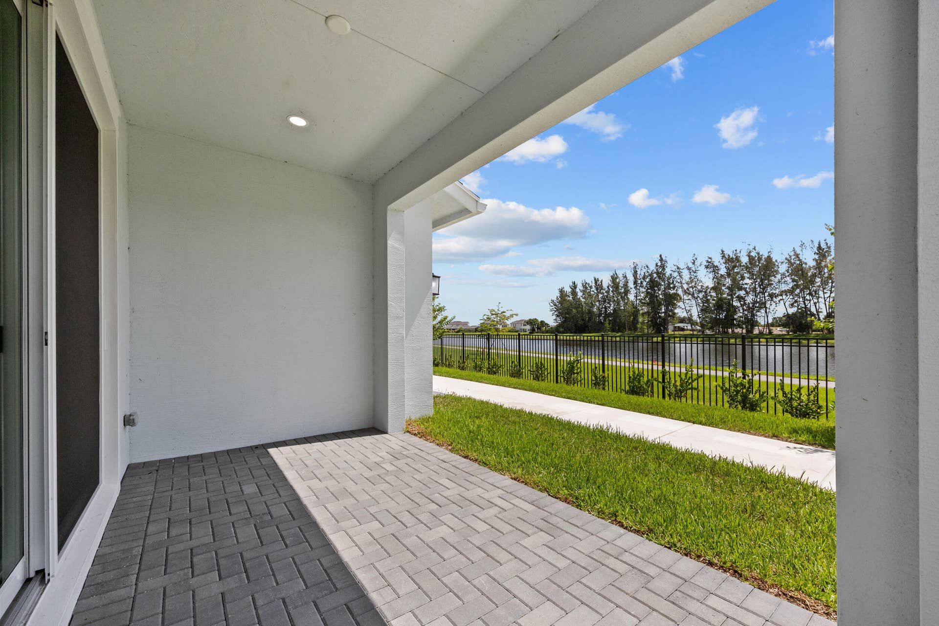 Covered patio featuring paver flooring, recessed lighting, and a sliding glass door