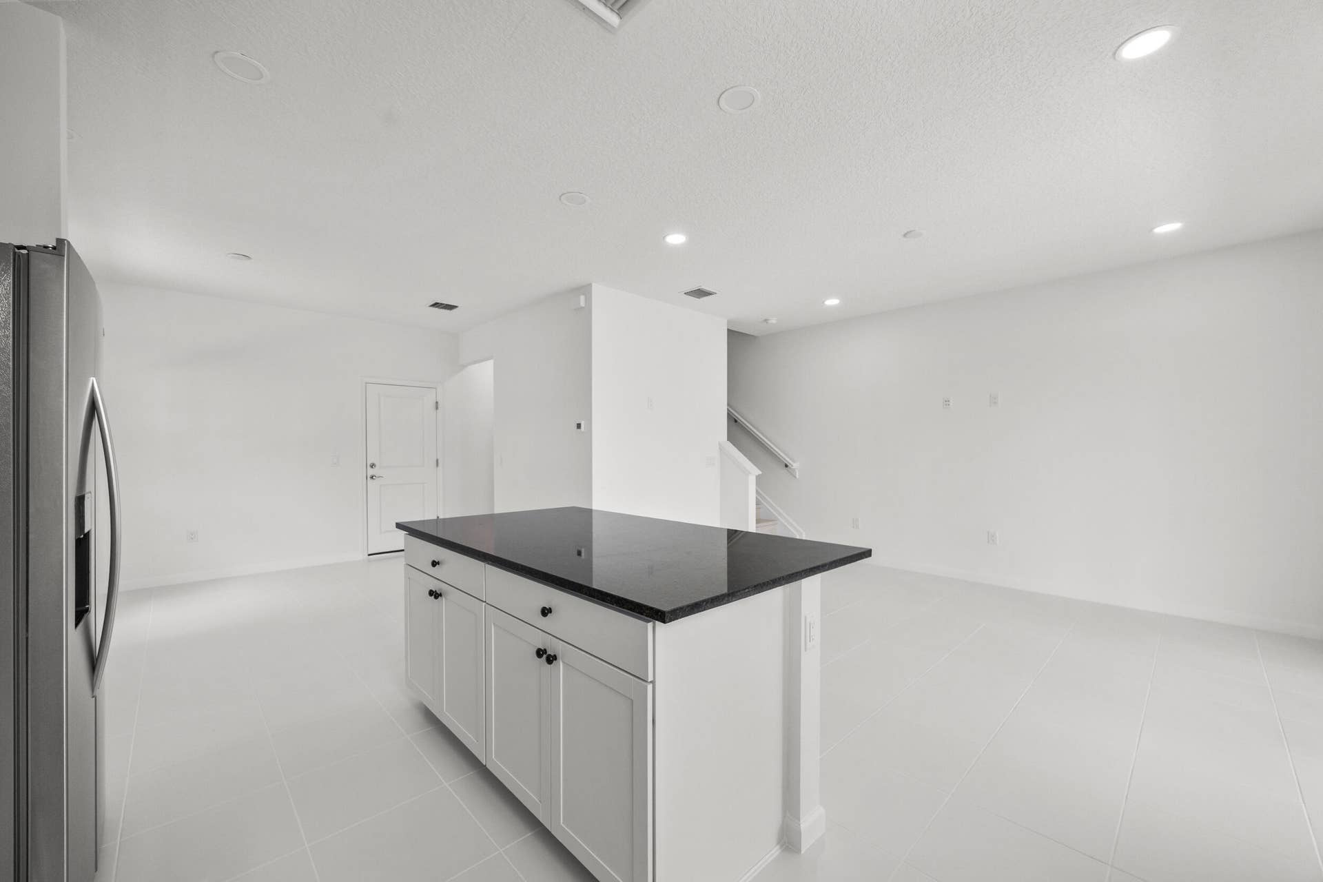 Kitchen island with a dark countertop and white cabinetry