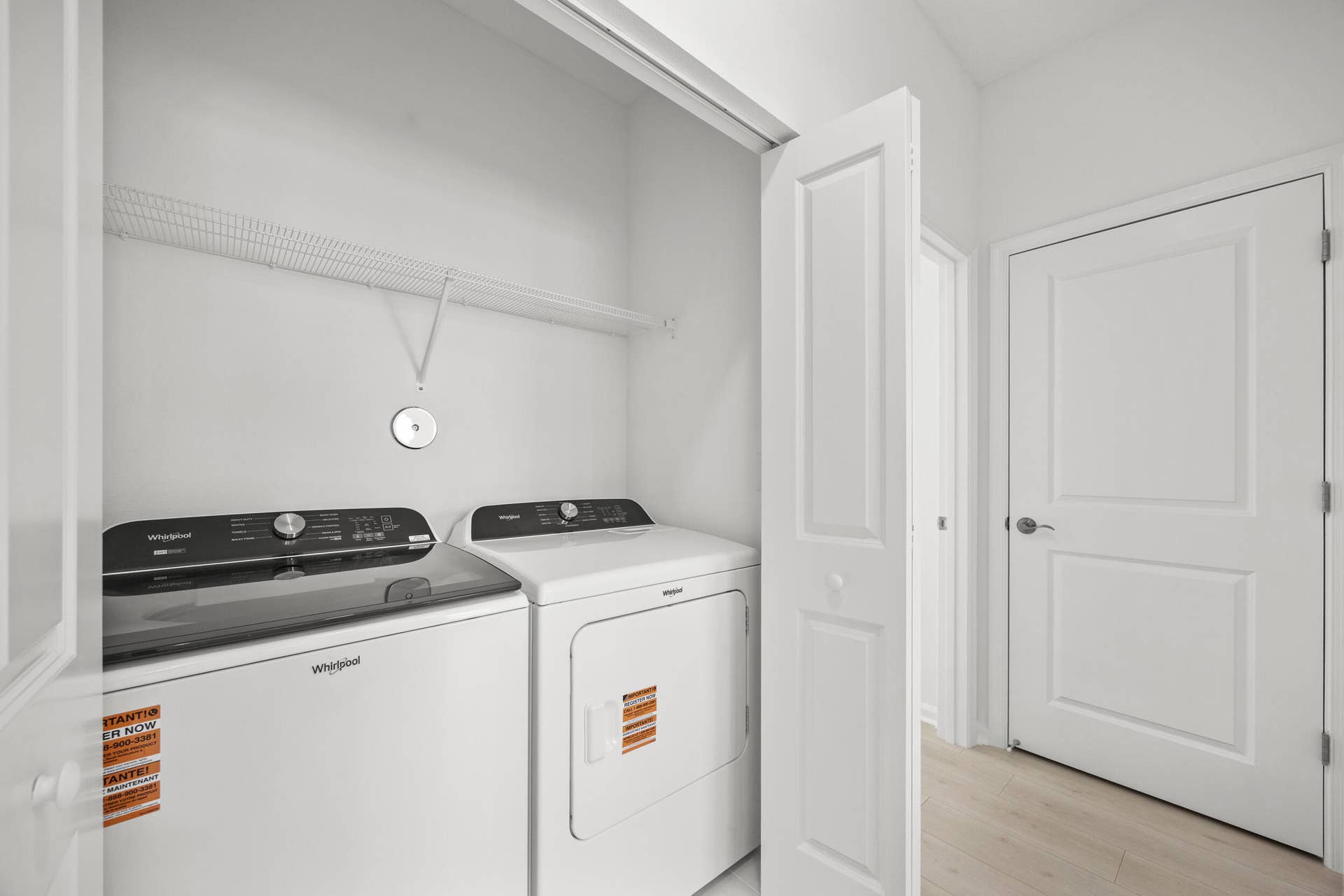 Laundry closet with wire shelving and a light wood-finish floor