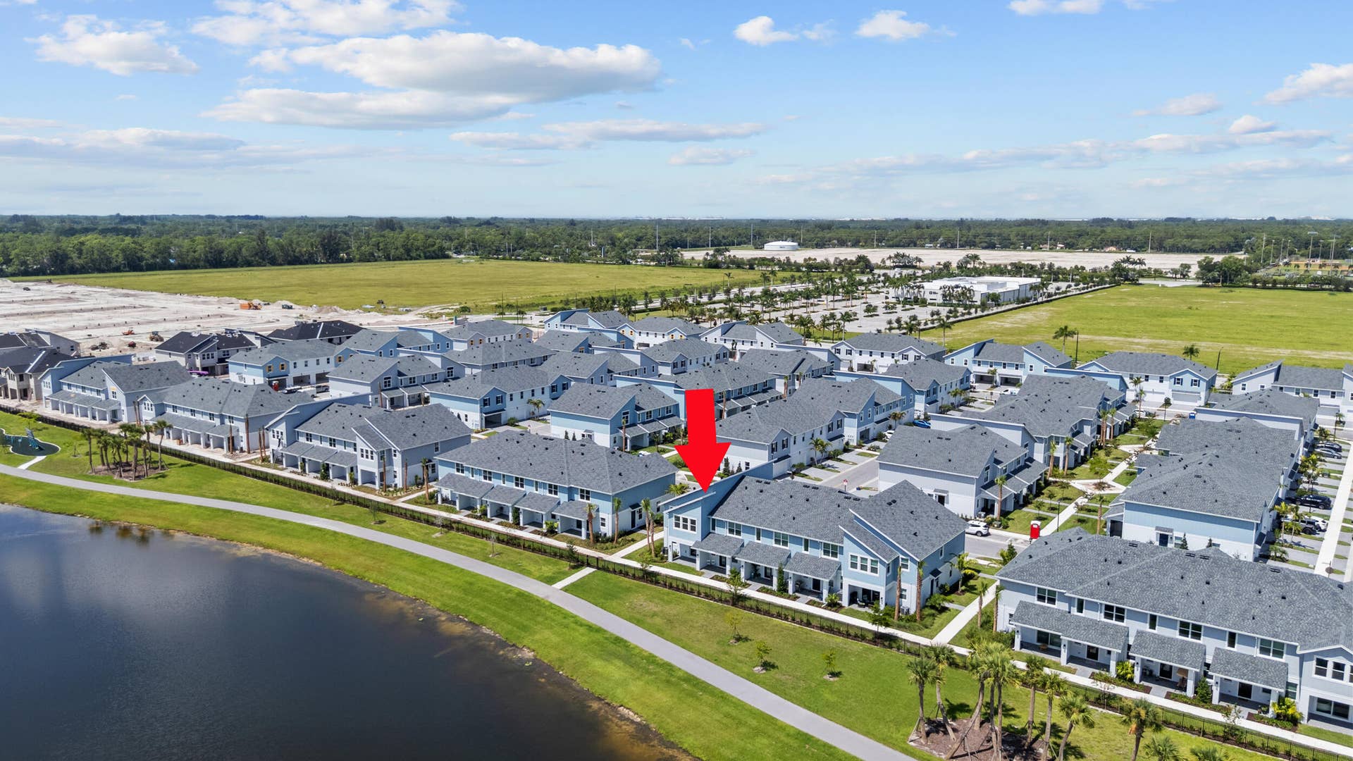 Waterfront property featuring a private driveway, attached garages, and a paved walkway
