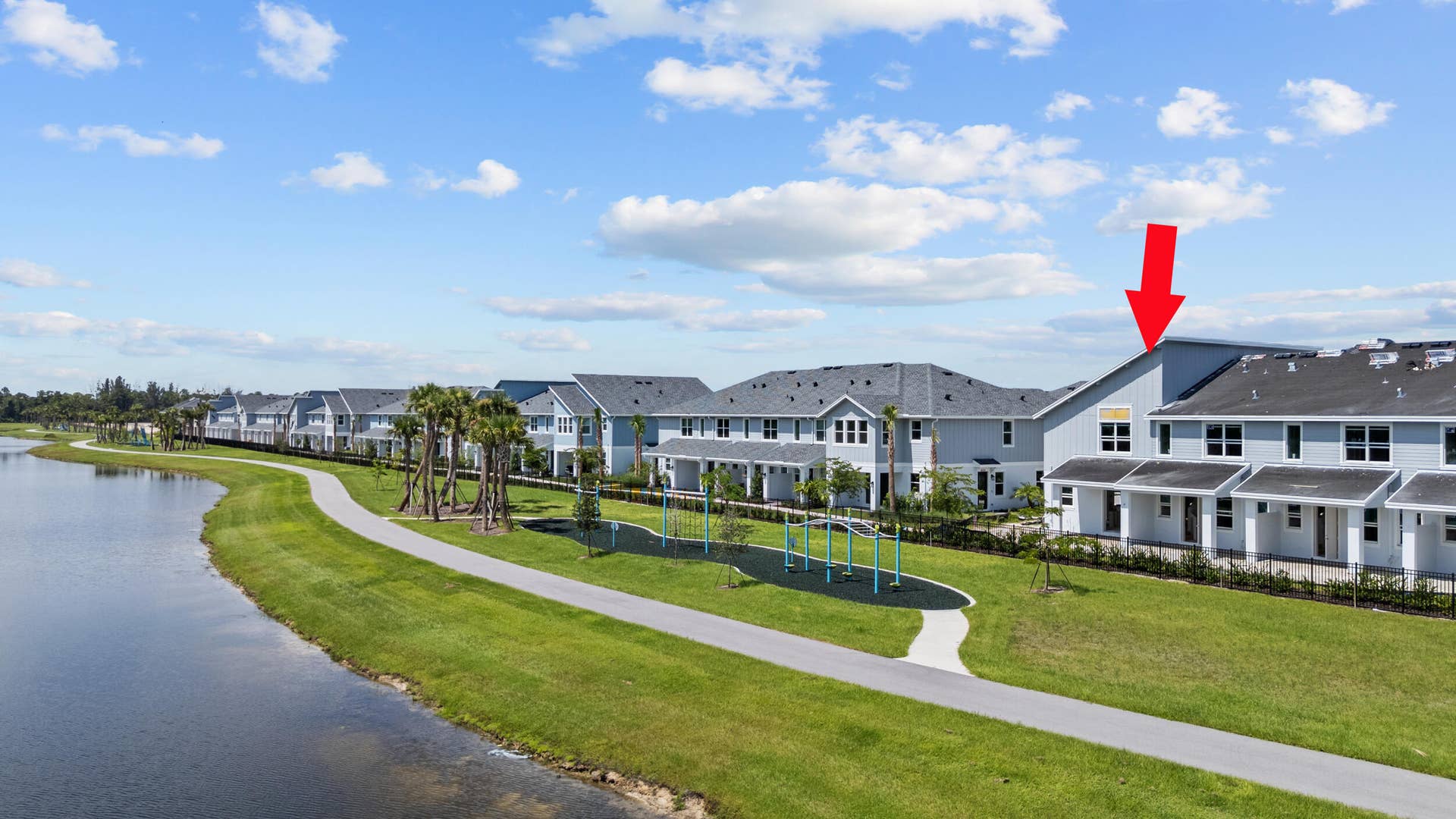 Waterfront property featuring light blue siding, white trim, and a dark shingle roof
