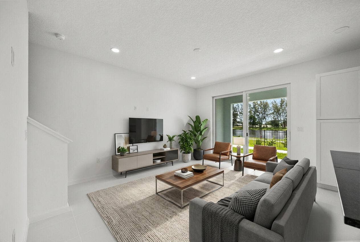 Recessed lighting, light-toned flooring, sliding glass door, white cabinetry, and a black countertop