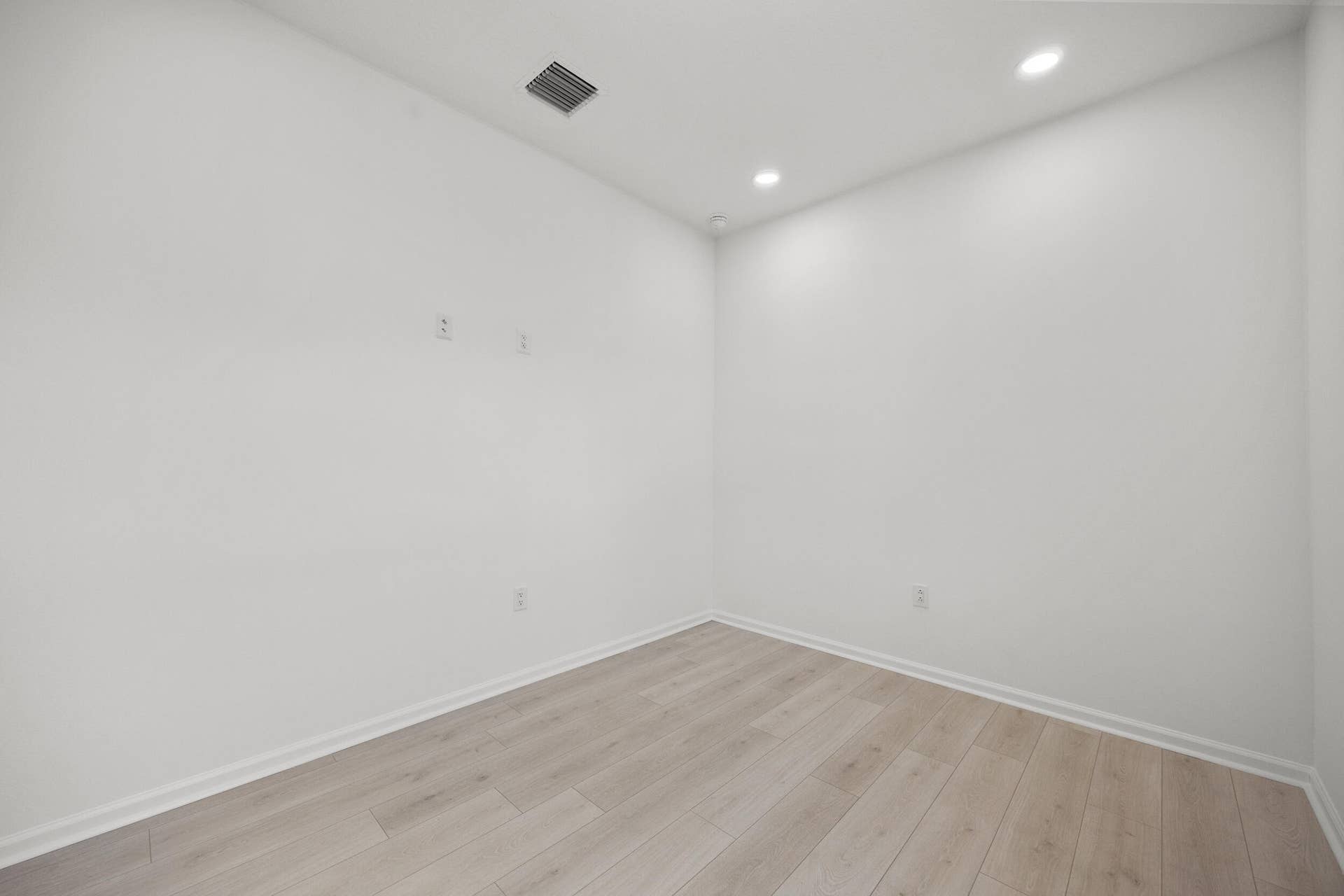 Recessed lighting, wood-finish flooring, white walls, and white trim