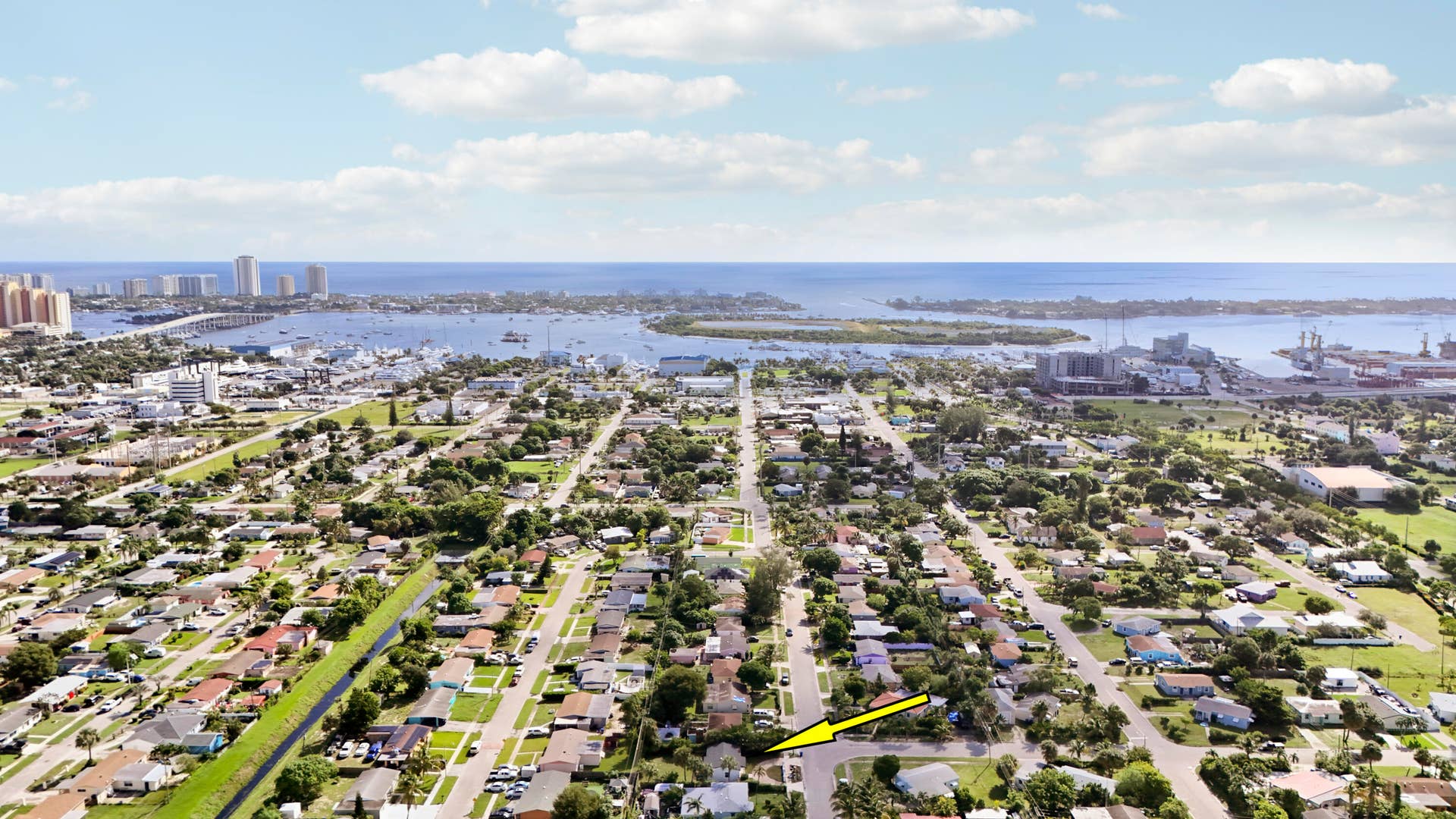 Aerial perspective showcasing a residential neighborhood with a distant waterway and urban skyline