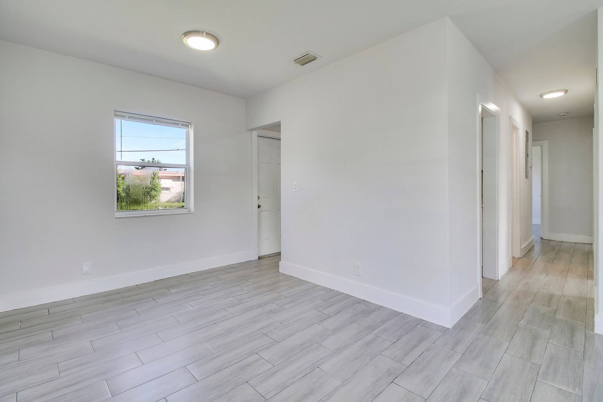 Light gray tile flooring throughout, white walls, and recessed lighting
