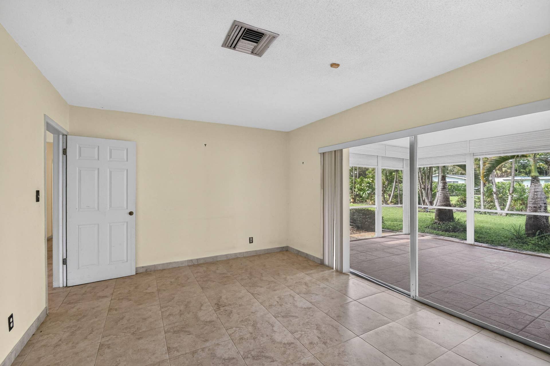 Tiled flooring throughout, neutral wall tones, and direct access to a screened patio