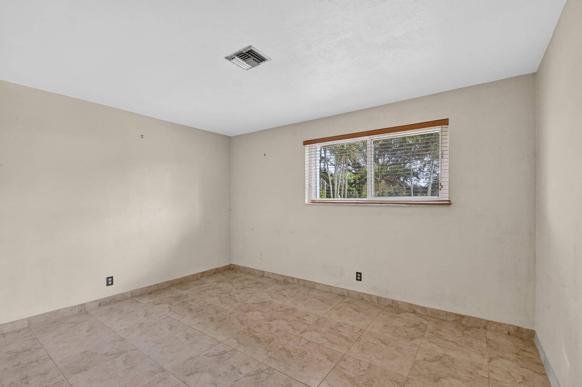 Window with horizontal blinds and wood-finish trim, set within neutral-toned walls
