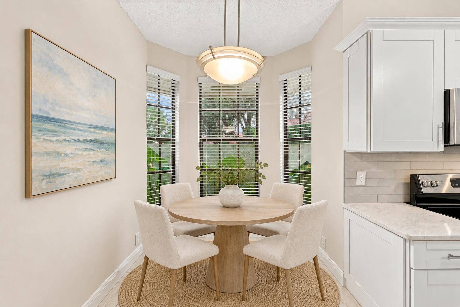 8292 WATERLINE Drive, #106, Boynton Beach, FL 33472 Bay window with three vertical windows, white cabinetry with silver hardware, light-colored countertops, and subway tile backsplash