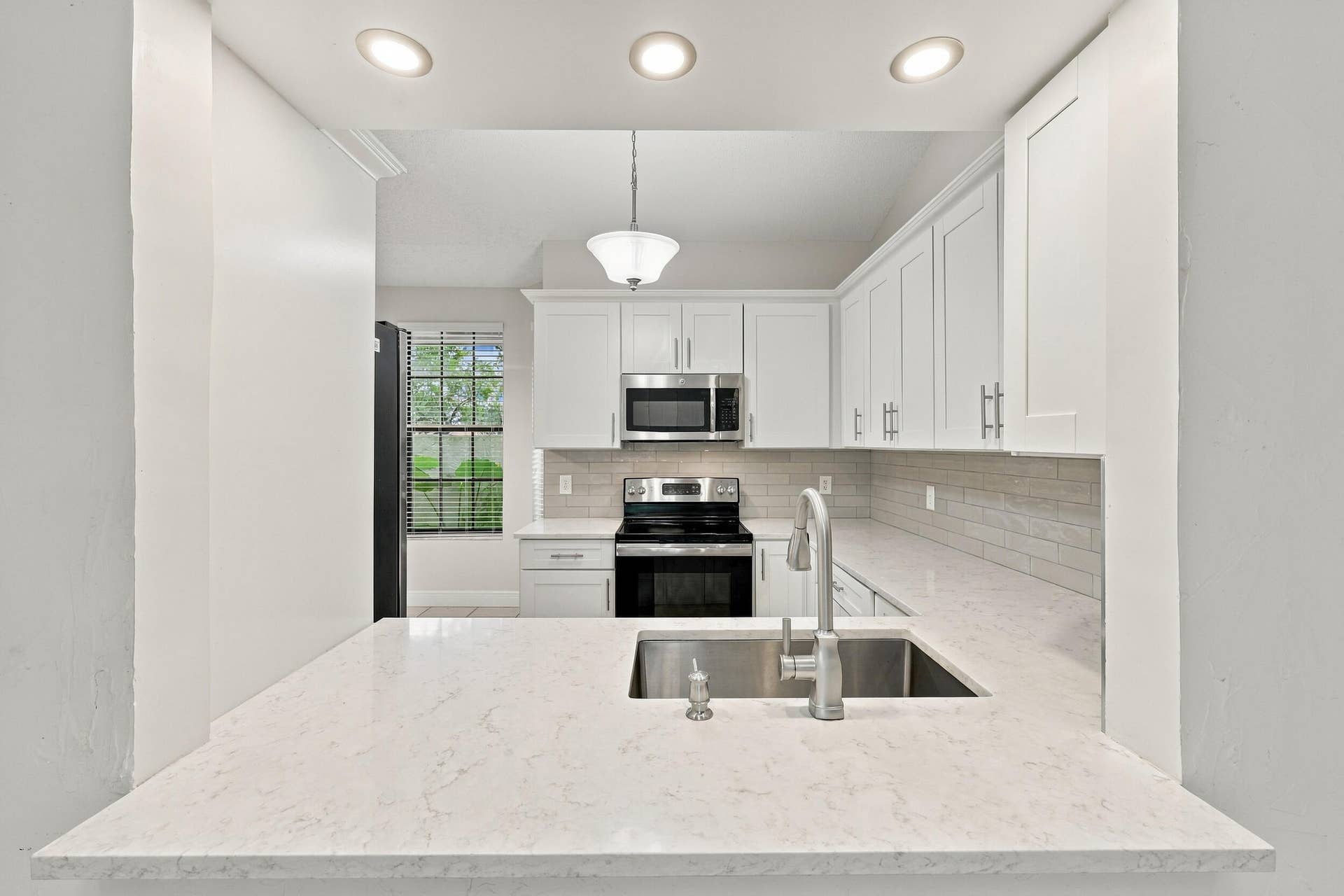 8292 WATERLINE Drive, #106, Boynton Beach, FL 33472 Breakfast bar with a large stainless steel sink and a single-handle faucet
