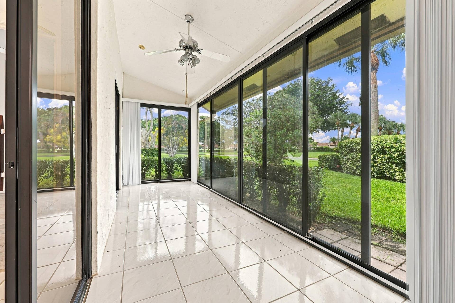 8292 WATERLINE Drive, #106, Boynton Beach, FL 33472 Enclosed patio featuring white tile flooring, a vaulted ceiling, and a ceiling fan