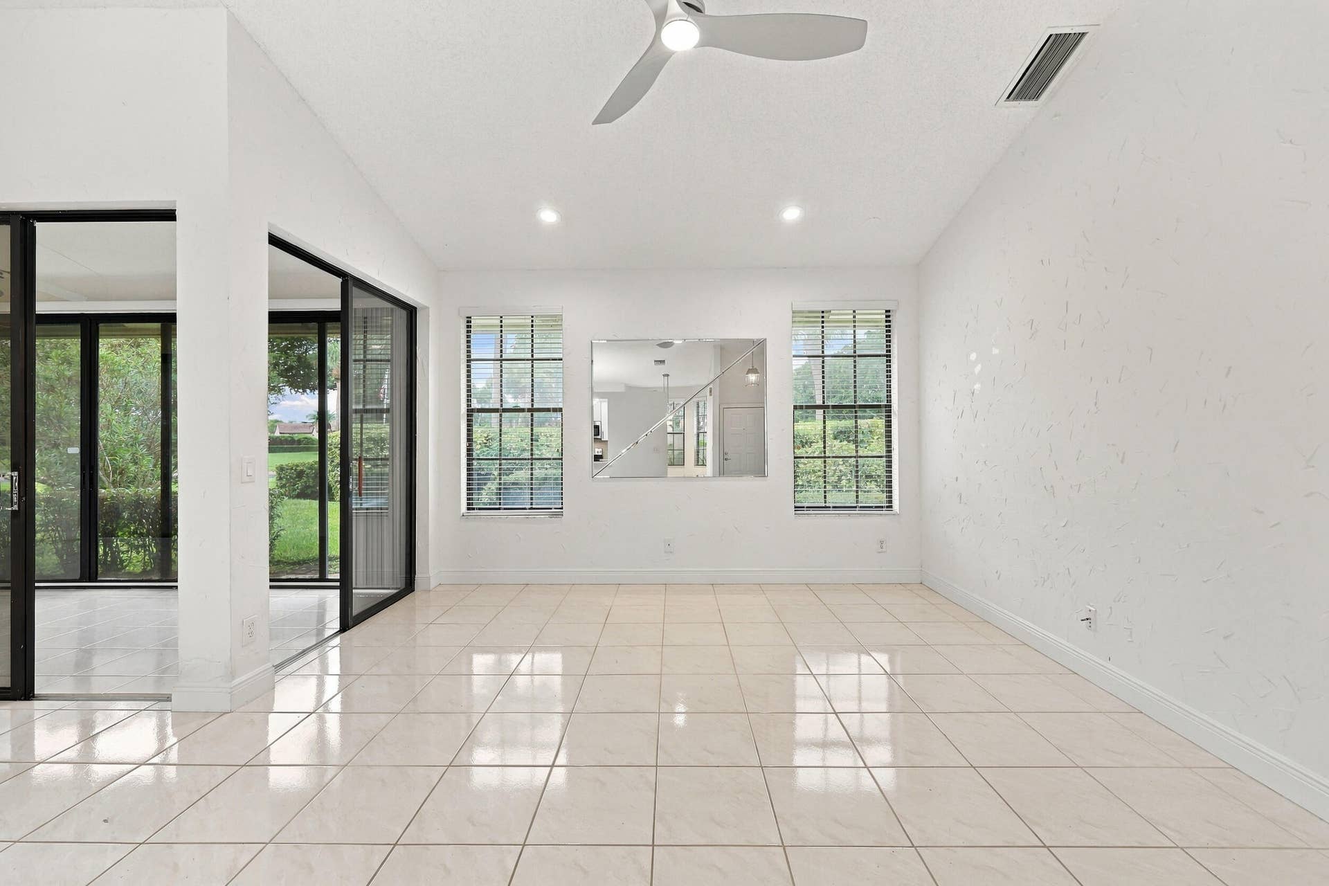 8292 WATERLINE Drive, #106, Boynton Beach, FL 33472 Expansive room featuring light-colored tile flooring, multiple windows with blinds, a ceiling fan, and recessed lighting