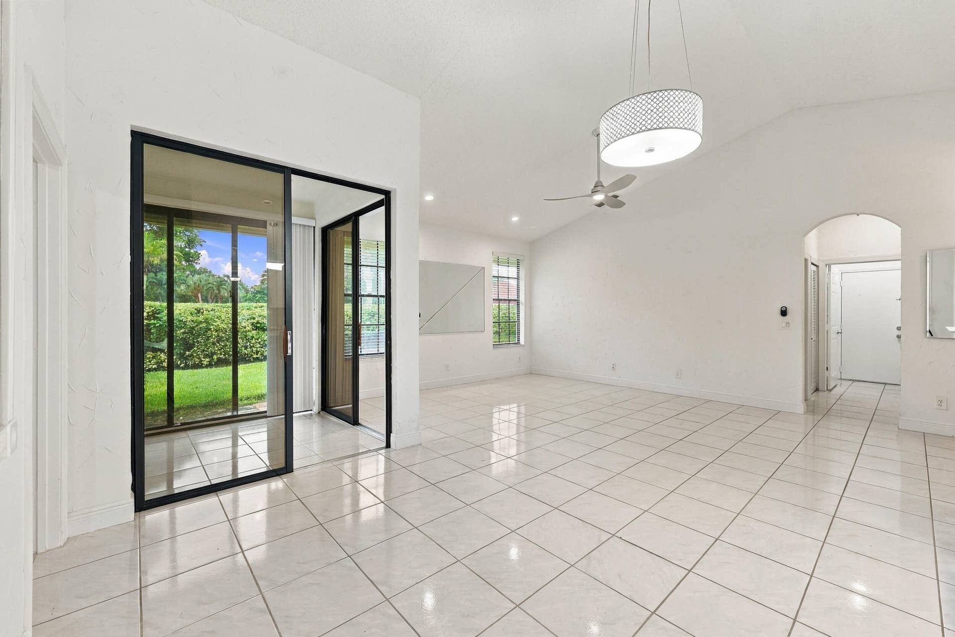 8292 WATERLINE Drive, #106, Boynton Beach, FL 33472 Expansive interior featuring large format tile flooring, vaulted ceilings, and a modern ceiling fan
