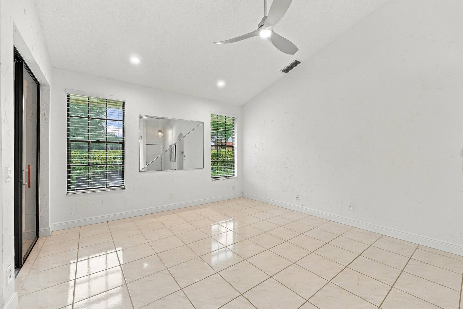 8292 WATERLINE Drive, #106, Boynton Beach, FL 33472 Vaulted ceiling with a ceiling fan and recessed lighting, tile flooring, and two windows with blinds