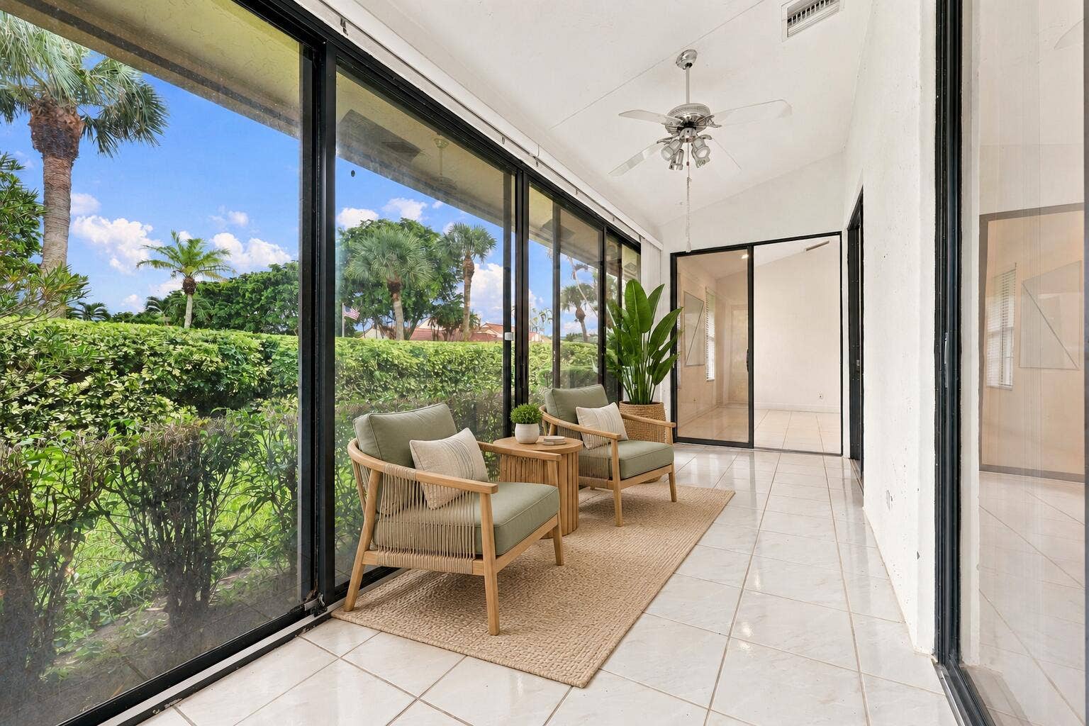 8292 WATERLINE Drive, #106, Boynton Beach, FL 33472 Expansive room featuring floor-to-ceiling sliding glass doors, a vaulted ceiling, and a ceiling fan