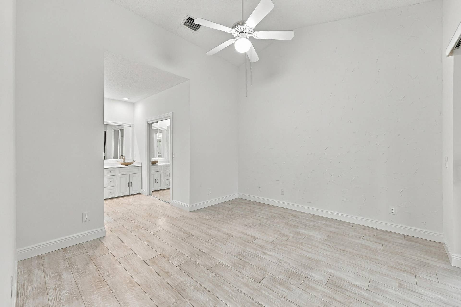 8292 WATERLINE Drive, #106, Boynton Beach, FL 33472 Vaulted ceiling with a ceiling fan, light wood-finish flooring, and white walls