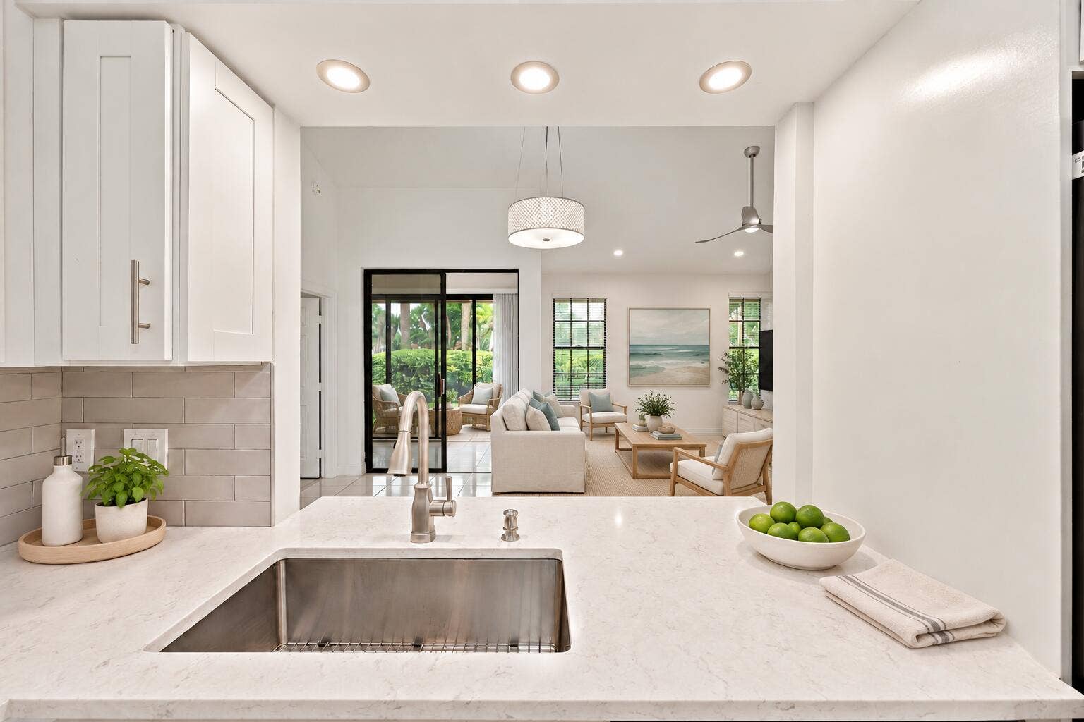 8292 Waterline Drive, #106, Boynton Beach, FL 33472 Stainless steel sink with a gooseneck faucet, light-toned countertop, white cabinetry with brushed nickel hardware, and a light subway tile backsplash