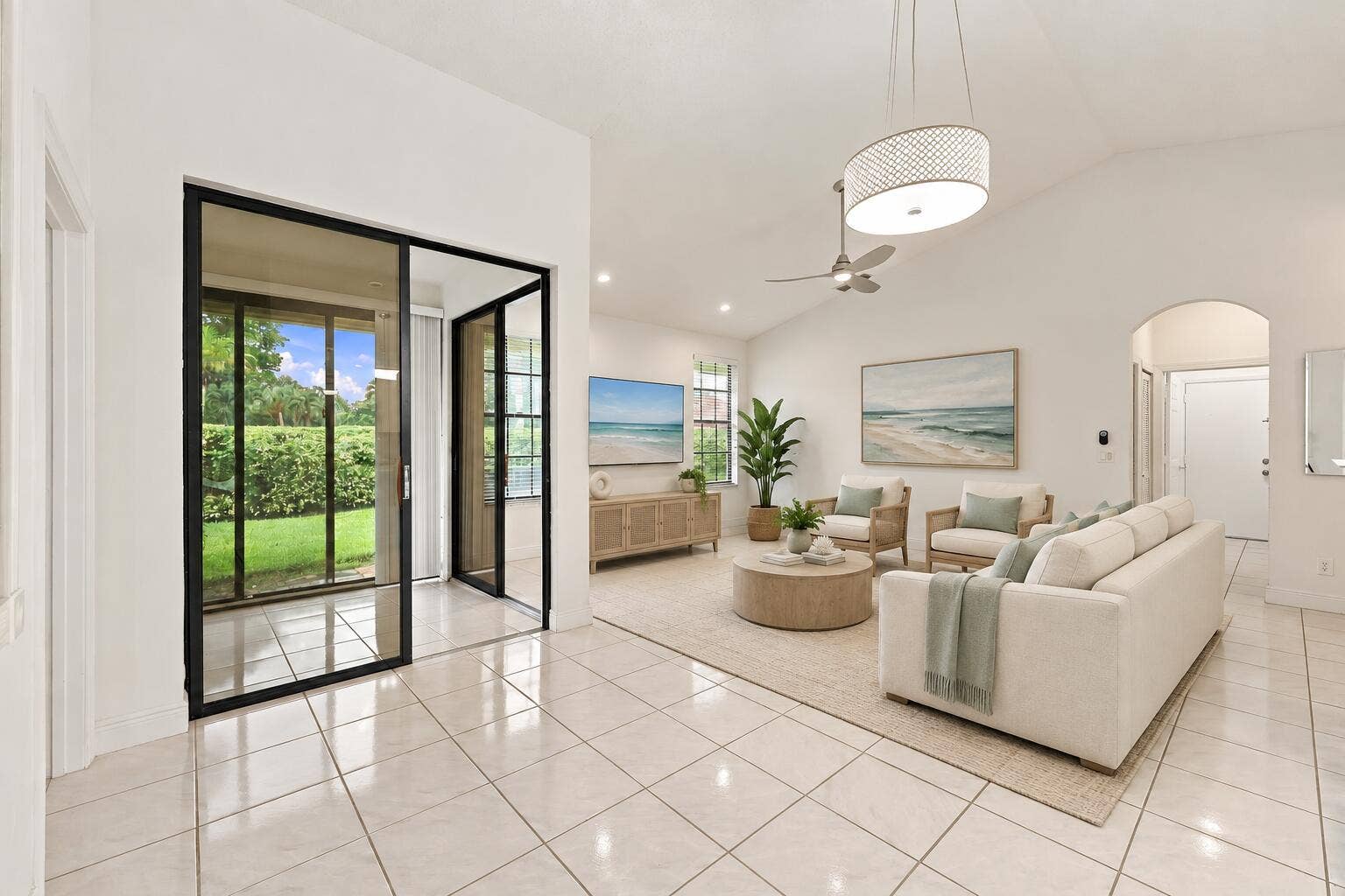 8292 Waterline Drive, #106, Boynton Beach, FL 33472 Vaulted ceilings, tiled flooring, arched doorway, ceiling fan, and black-framed glass doors