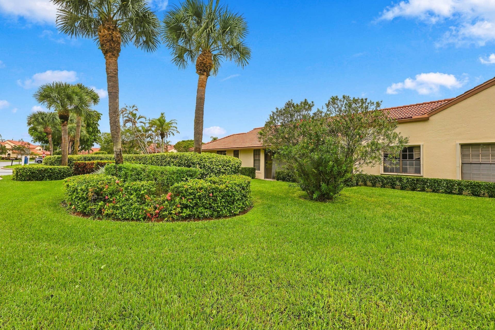 8292 Waterline Drive, #106, Boynton Beach, FL 33472 Manicured landscaping with mature palm trees and sculpted hedges