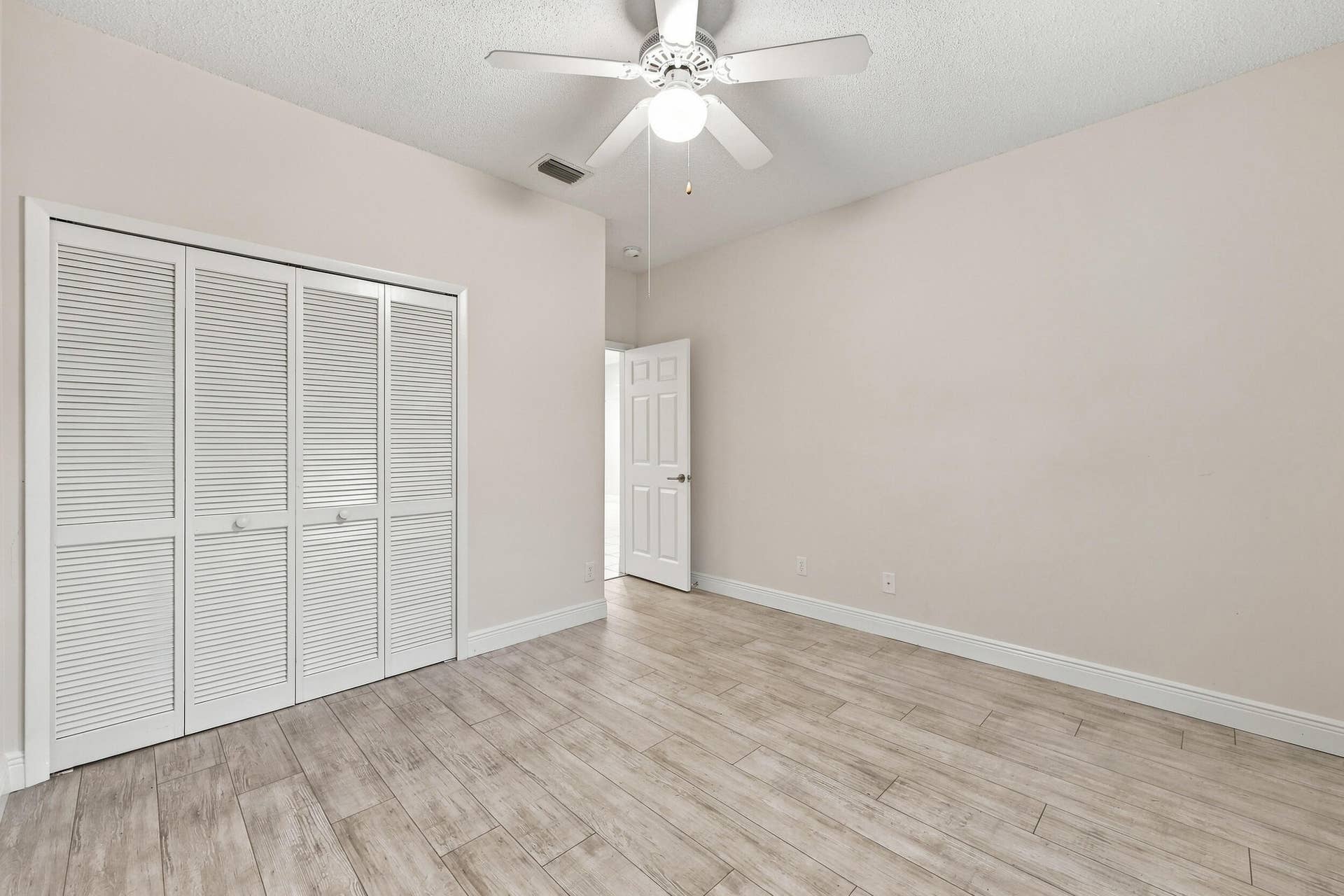8292 Waterline Drive, #106, Boynton Beach, FL 33472 Wood-finish flooring throughout, complemented by a white ceiling fan with integrated lighting