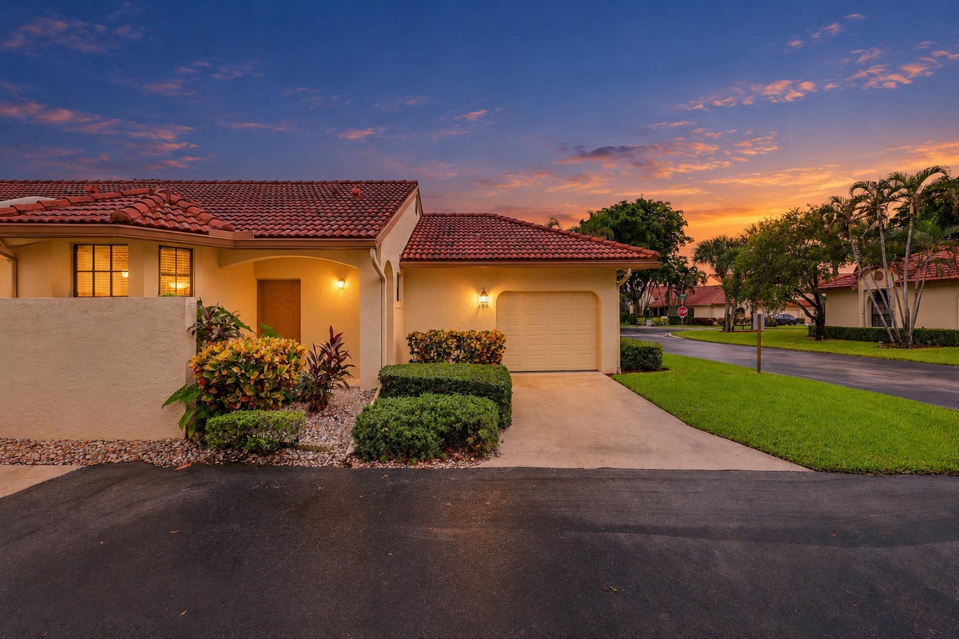 8292 Waterline Drive, #106, Boynton Beach, FL 33472 Mediterranean-style exterior with a tile roof, an integrated single-car garage, and a concrete driveway