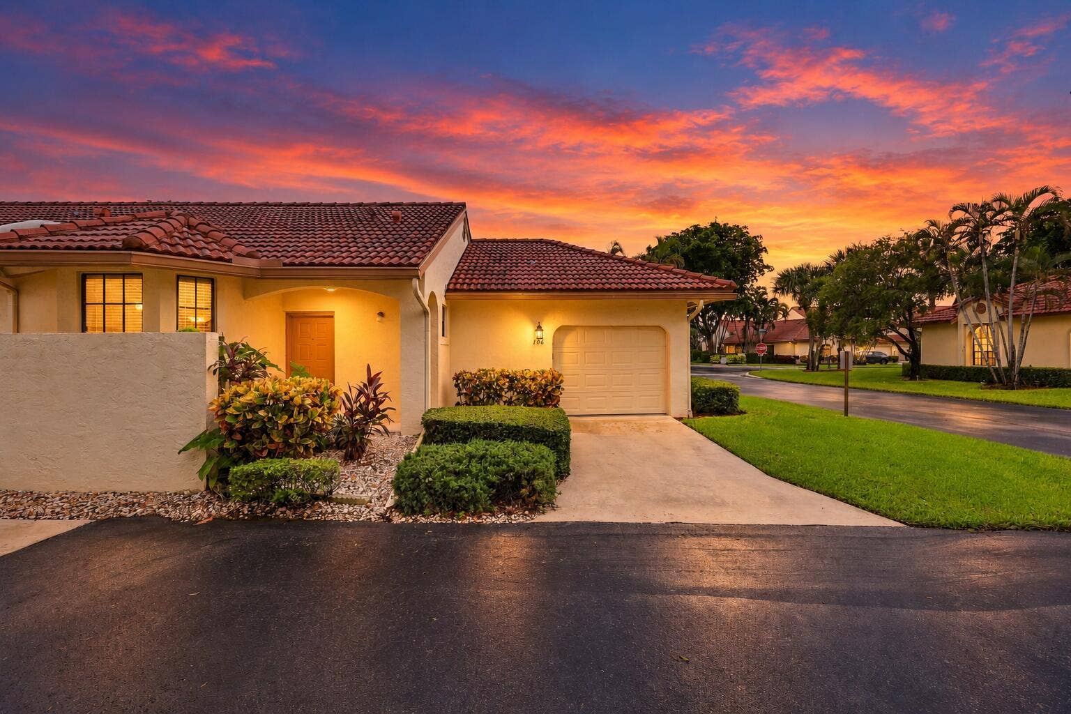 8292 Waterline Drive, #106, Boynton Beach, FL 33472 Mediterranean-style exterior with a terra cotta tile roof, light-colored stucco finish, and an attached garage