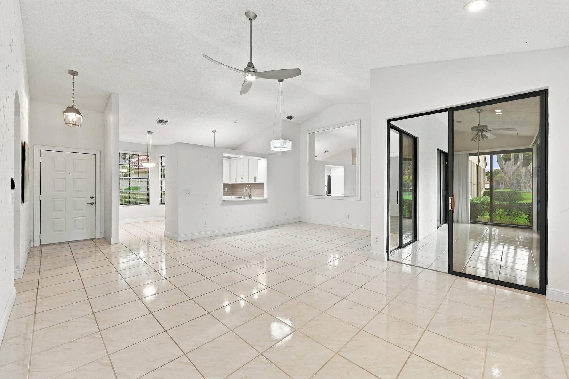 8292 Waterline Drive, #106, Boynton Beach, FL 33472 Spacious interior featuring vaulted ceilings, large format tile flooring, and multiple ceiling fans