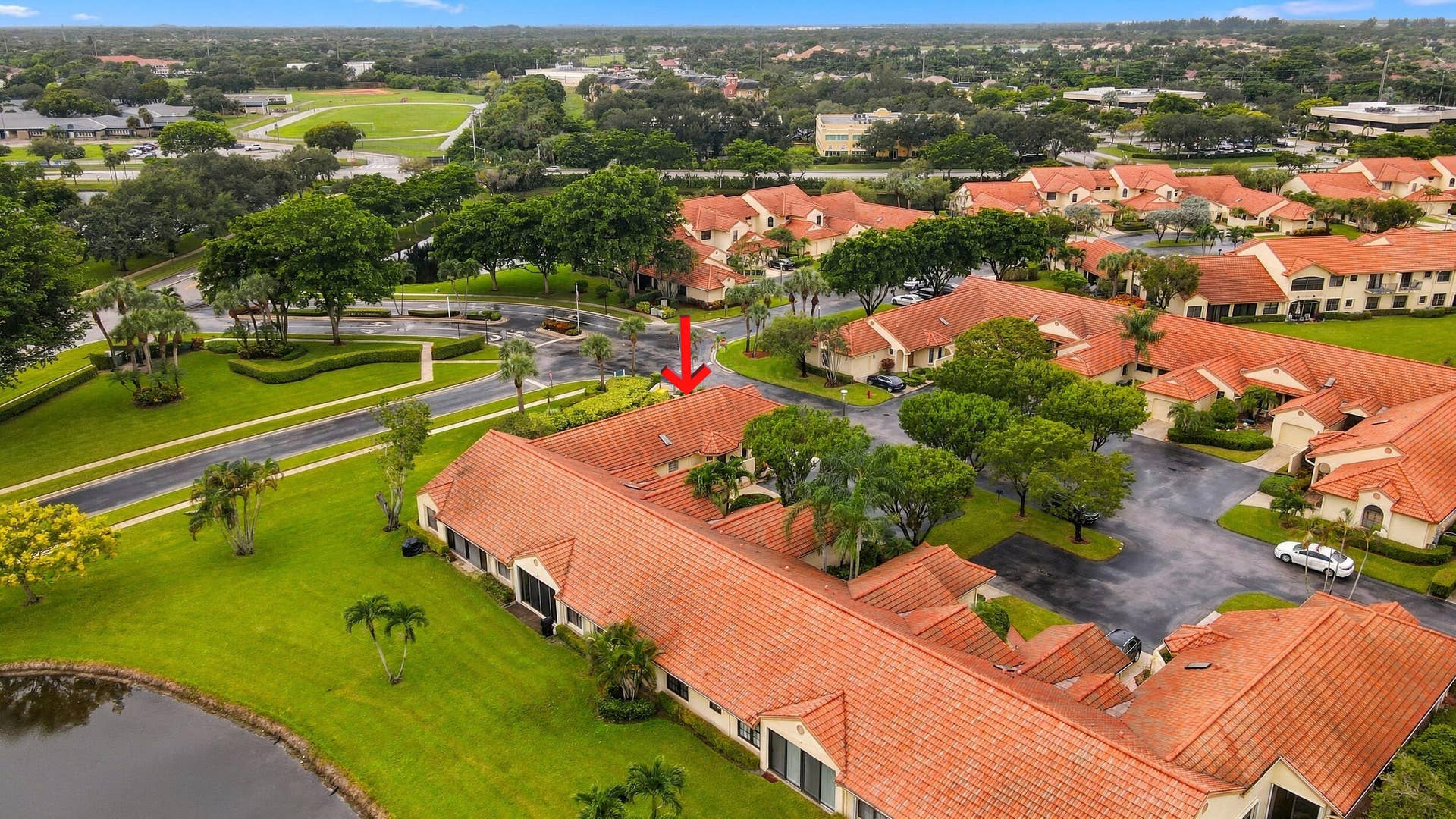 8292 Waterline Drive, #106, Boynton Beach, FL 33472 Aerial perspective showcasing a residential community with abundant green spaces, mature trees, and a pond
