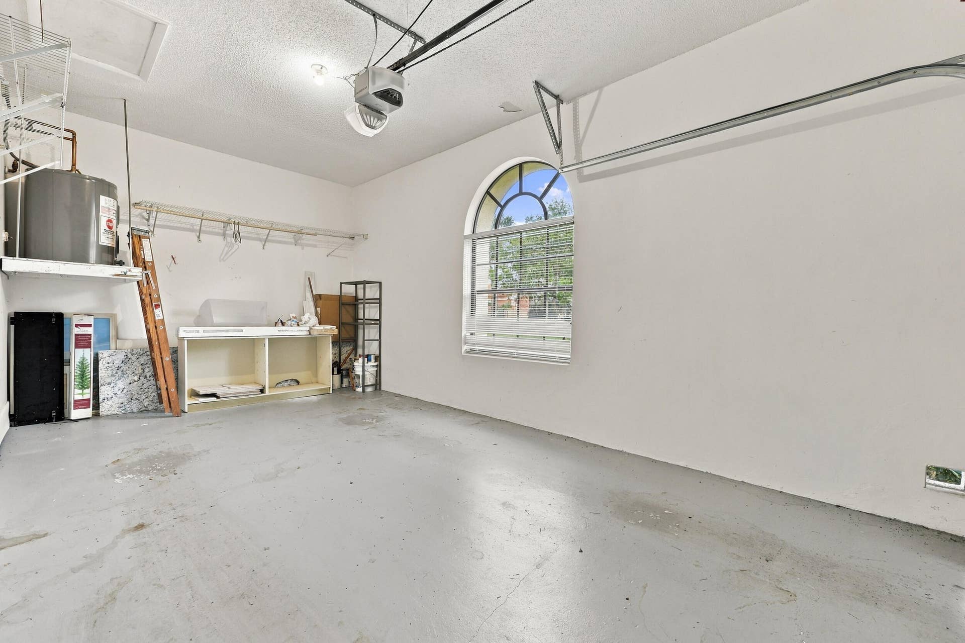 8292 Waterline Drive, #106, Boynton Beach, FL 33472 Garage featuring a light gray concrete floor and a transom window