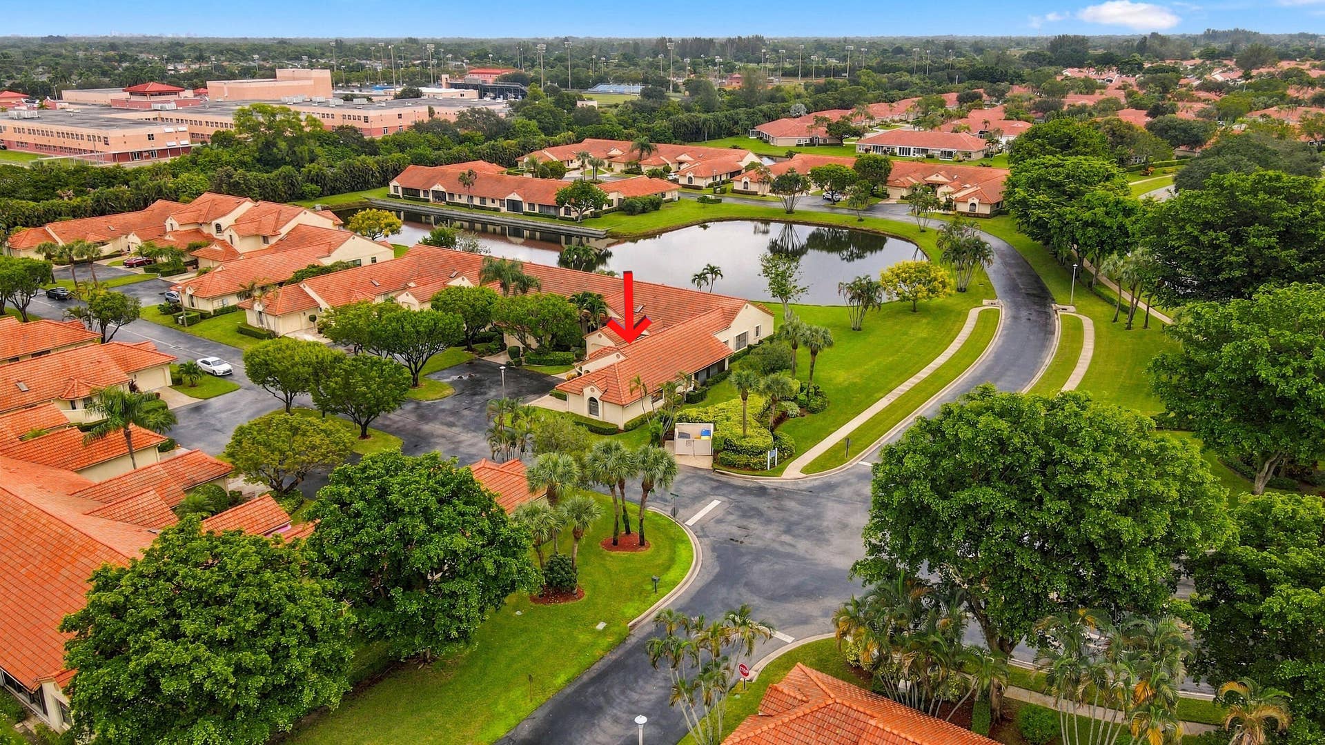 8292 Waterline Drive, #106, Boynton Beach, FL 33472 Residential community featuring a central pond, paved roads, and lush landscaping