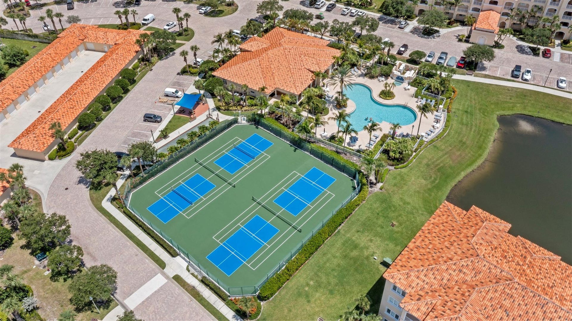 9 HARBOUR ISLE Drive E, #102, Fort Pierce, FL 34949 Aerial view of pickleball/tennis courts, pool, and clubhouse