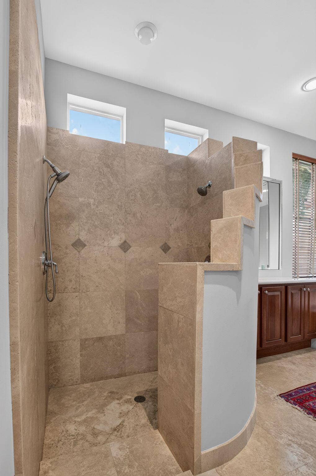 6610 Aston Lane, Boynton Beach, FL 33437 Walk-in shower with natural stone-look tile, integrated bench seating, and dual shower heads