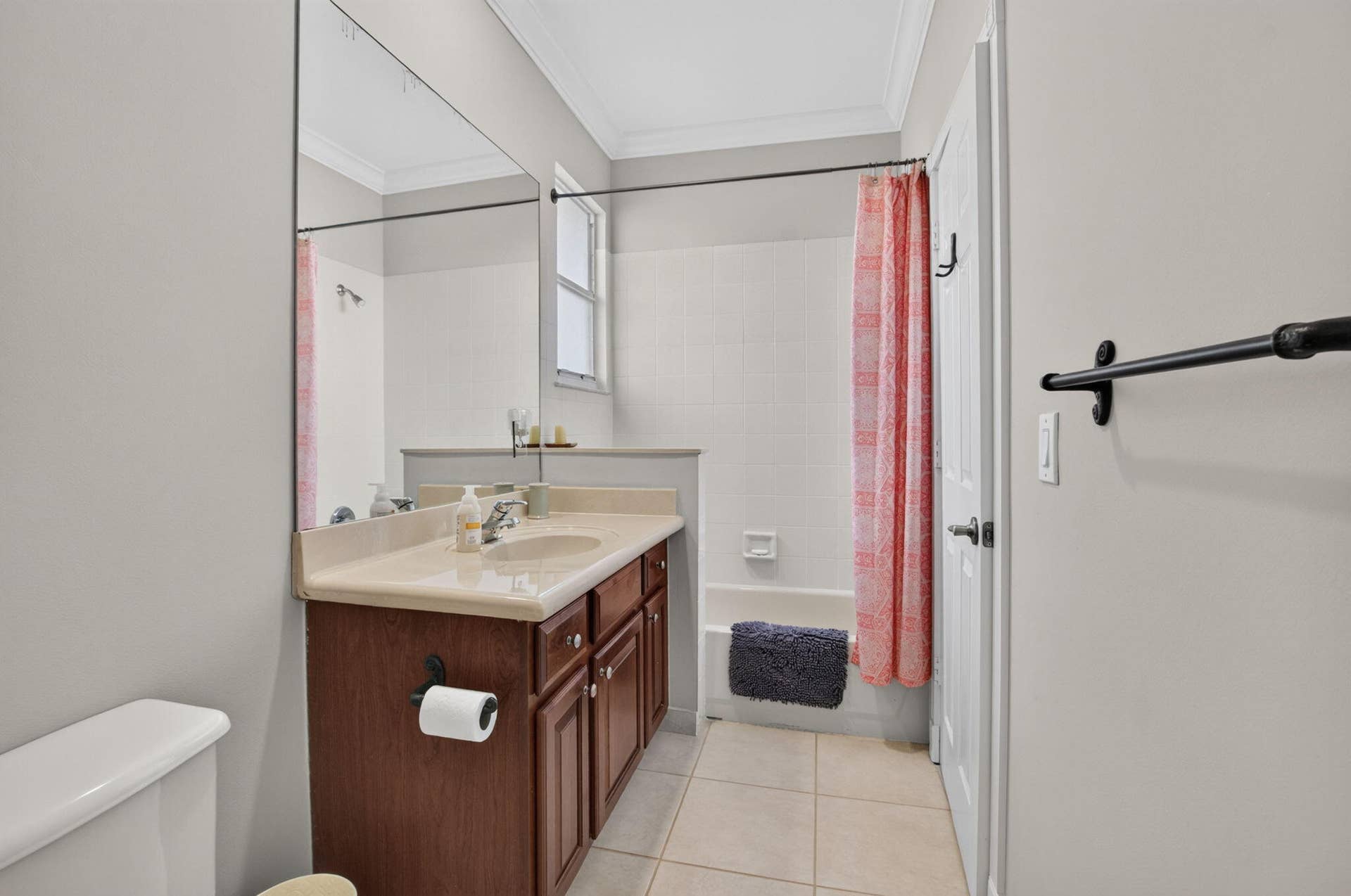 6610 Aston Lane, Boynton Beach, FL 33437 Bathroom featuring a wood-finish vanity with an integrated sink and light-toned countertop, a full-wall mirror, and a tiled shower/tub combination