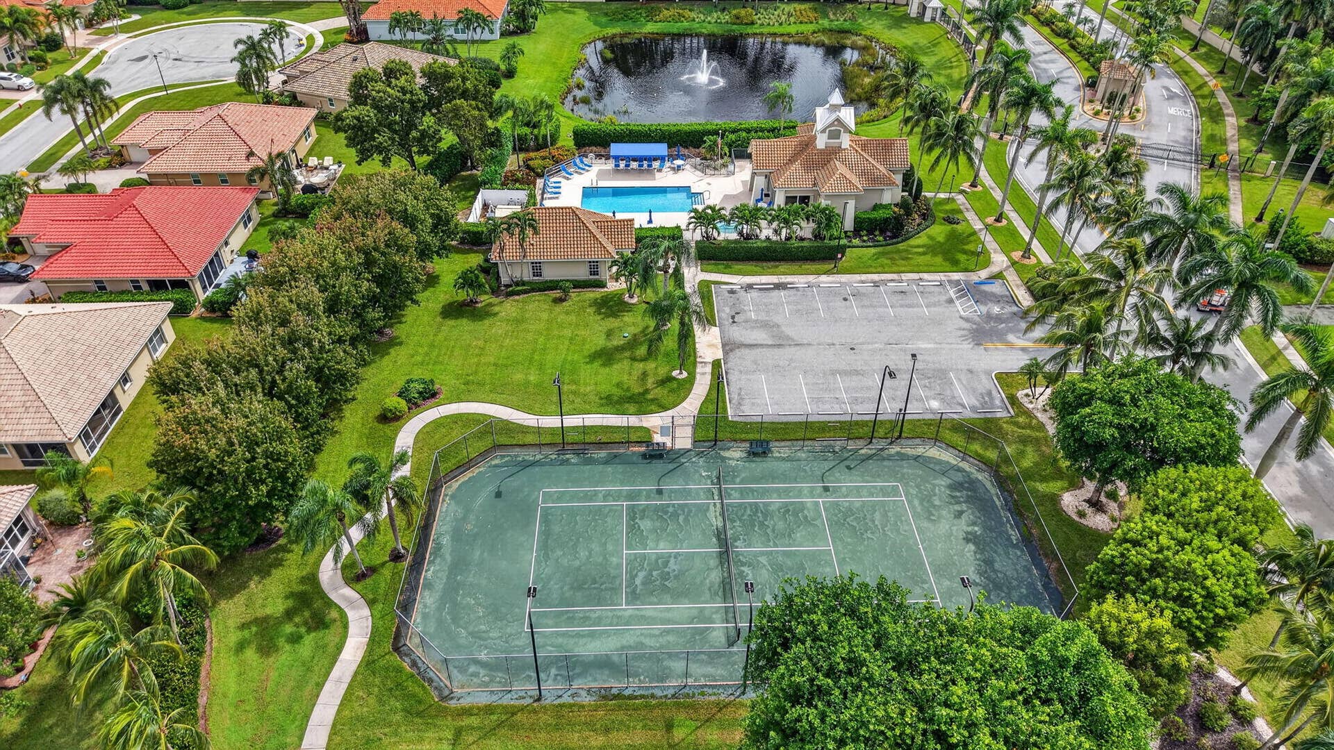 6610 Aston Lane, Boynton Beach, FL 33437 Community amenities include a tennis court, swimming pool, clubhouse, and a tranquil pond with a water feature